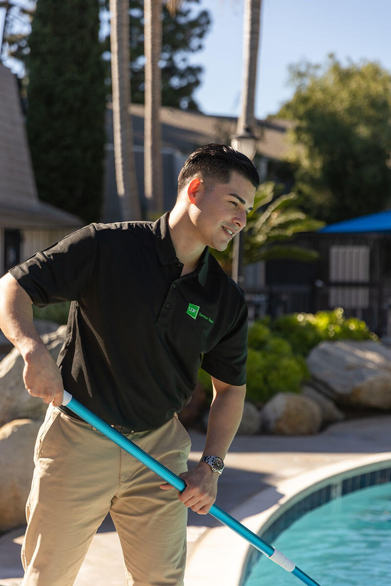 service man cleaning pool