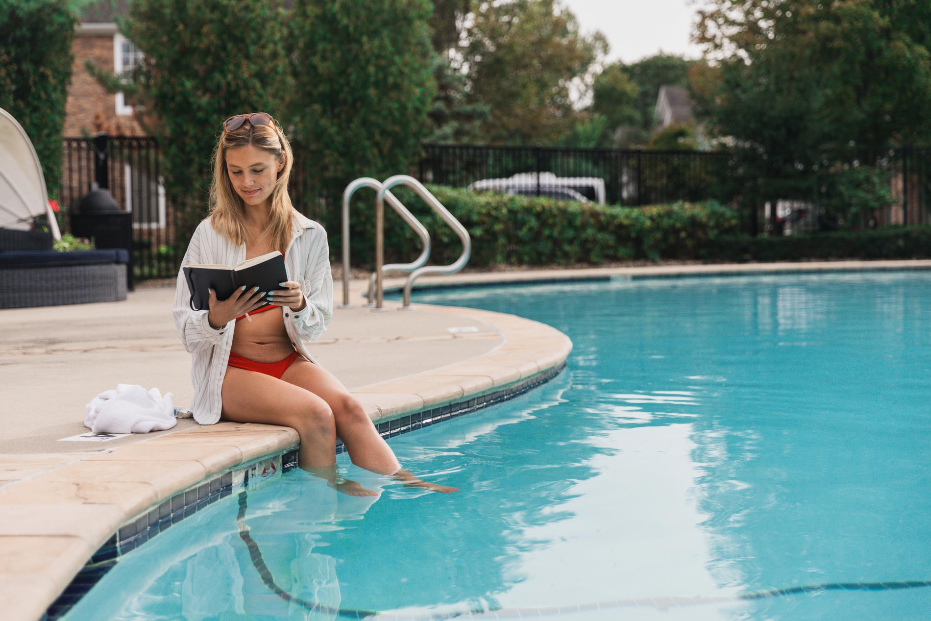 Lenox Farms a woman sits by the pool reading