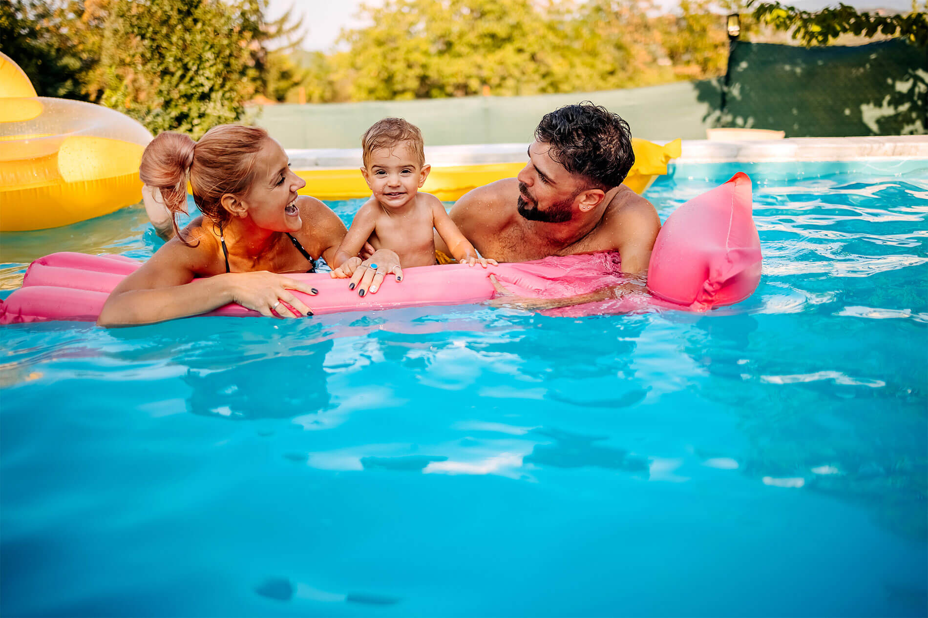 Happy family swimming in the pool