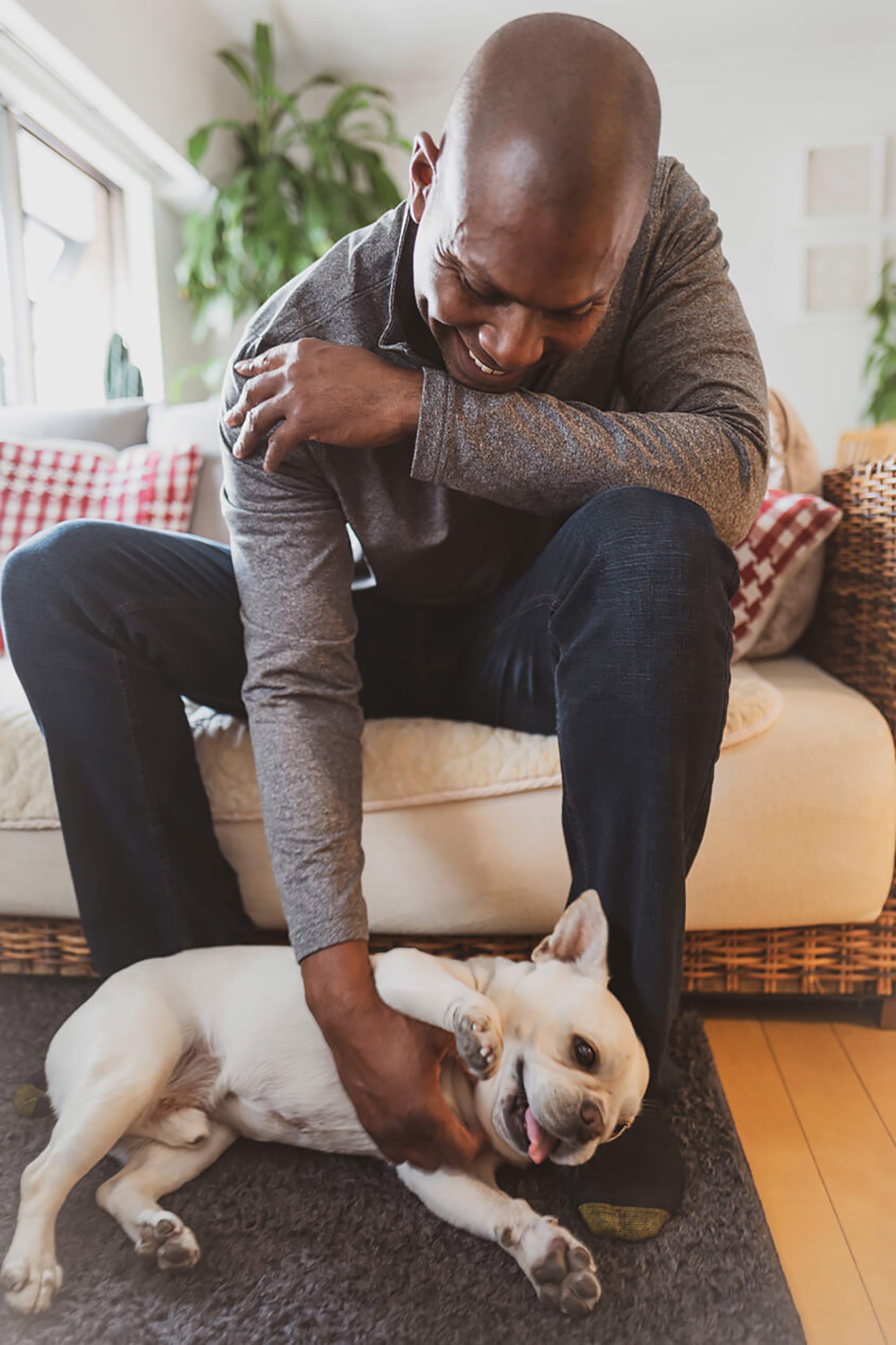 Man petting dog next to couch