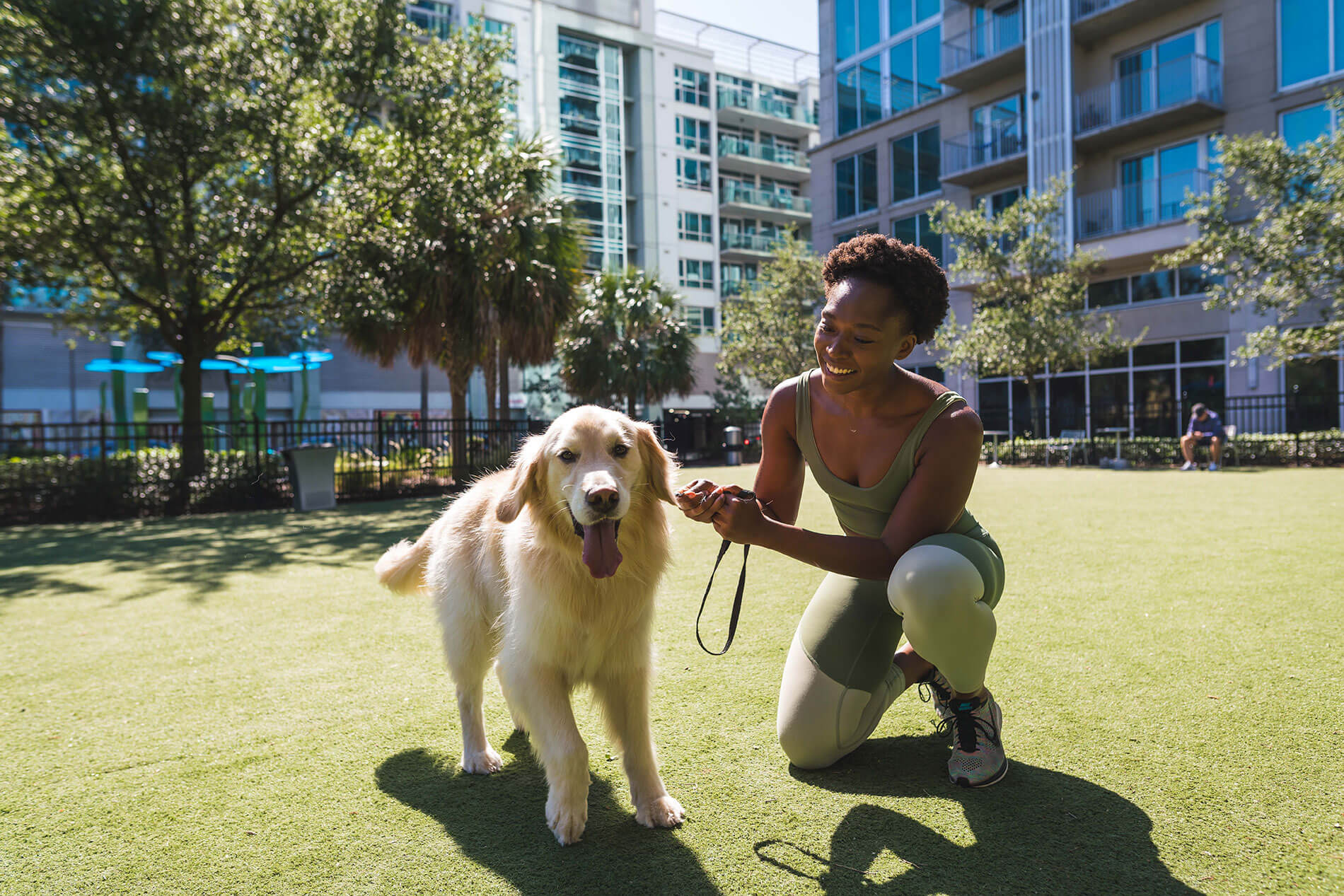 101 N. Meridian woman in workout attire at a dog park with a happy dog