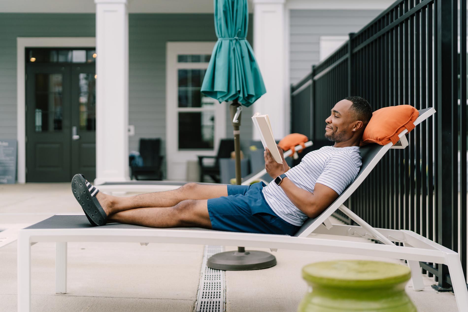 1274 At Towson Apartments Man Reading Book in Pool Chair