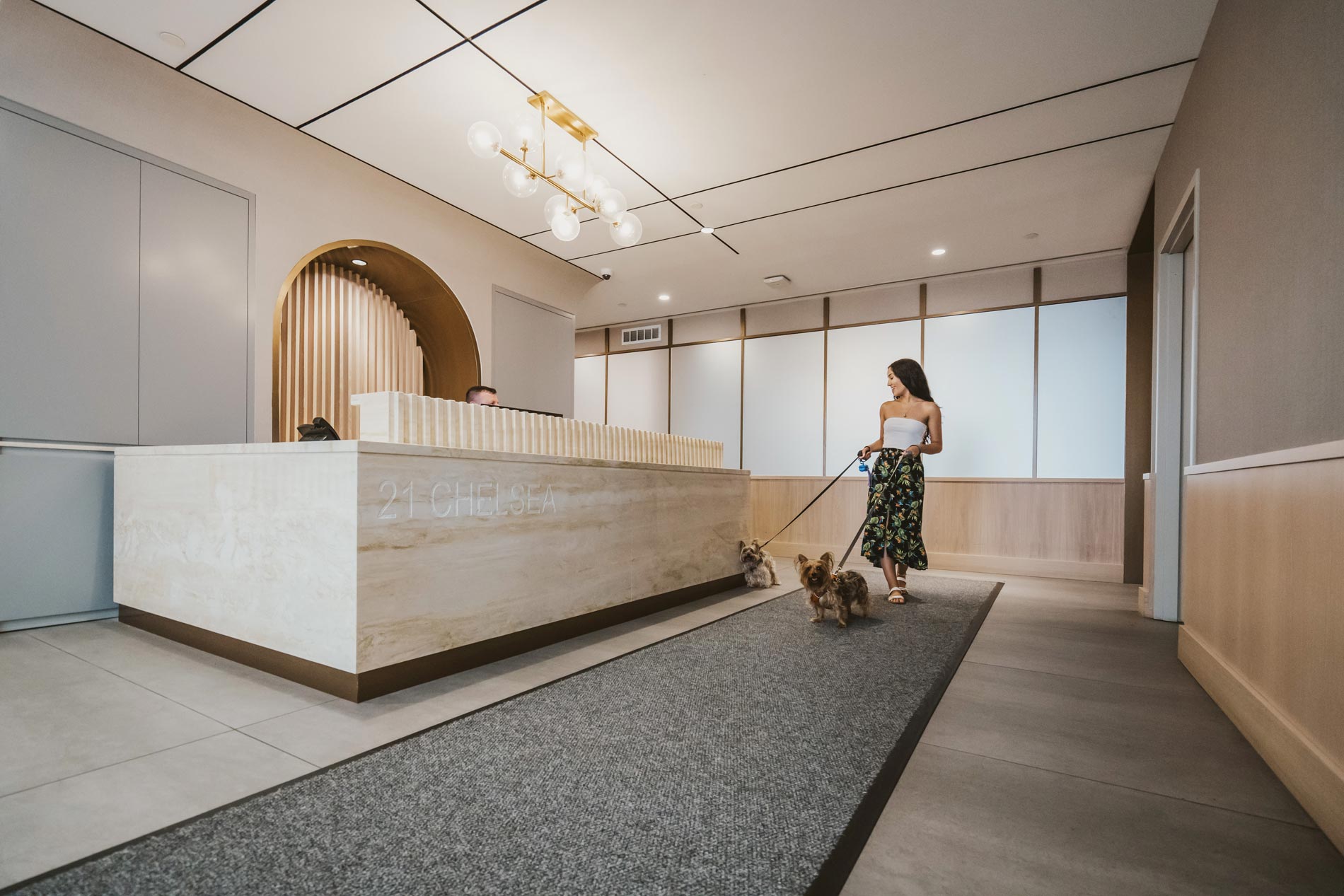 21 Chelsea woman walks through lobby with dogs