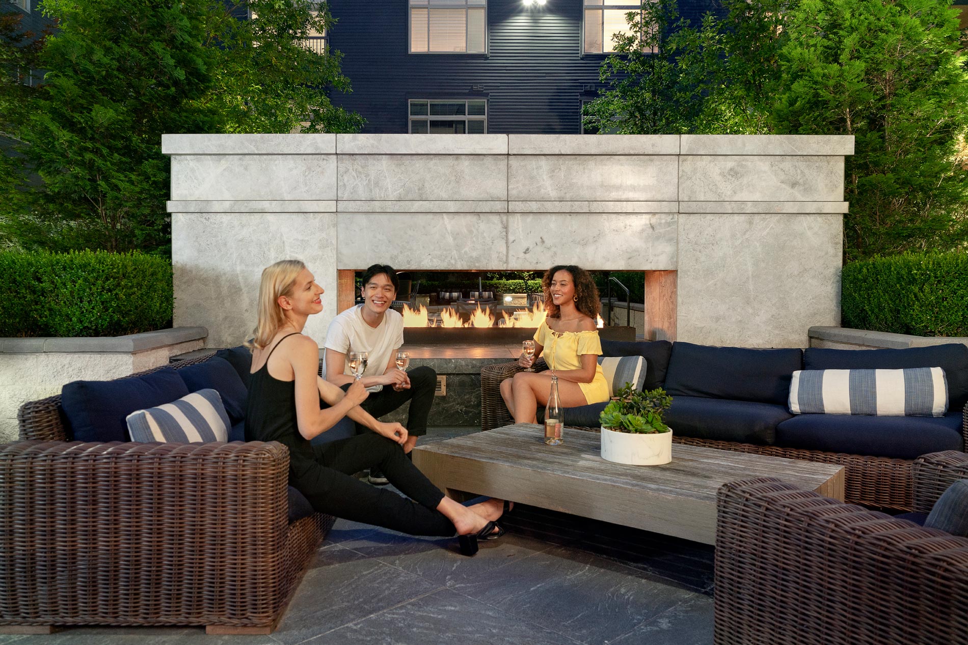 friends socializing by outdoor fireplace