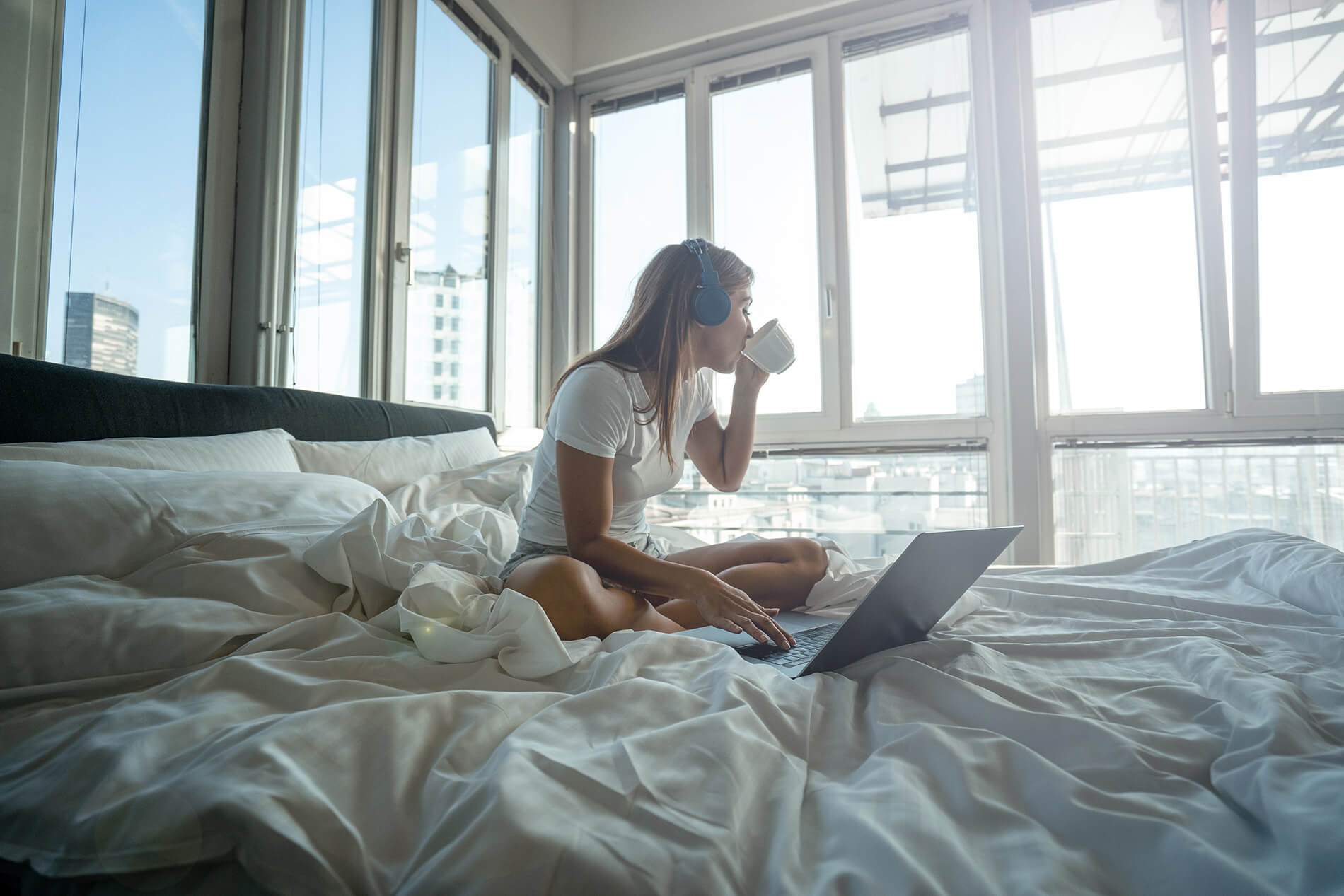 Girl sitting in bed drinking coffee