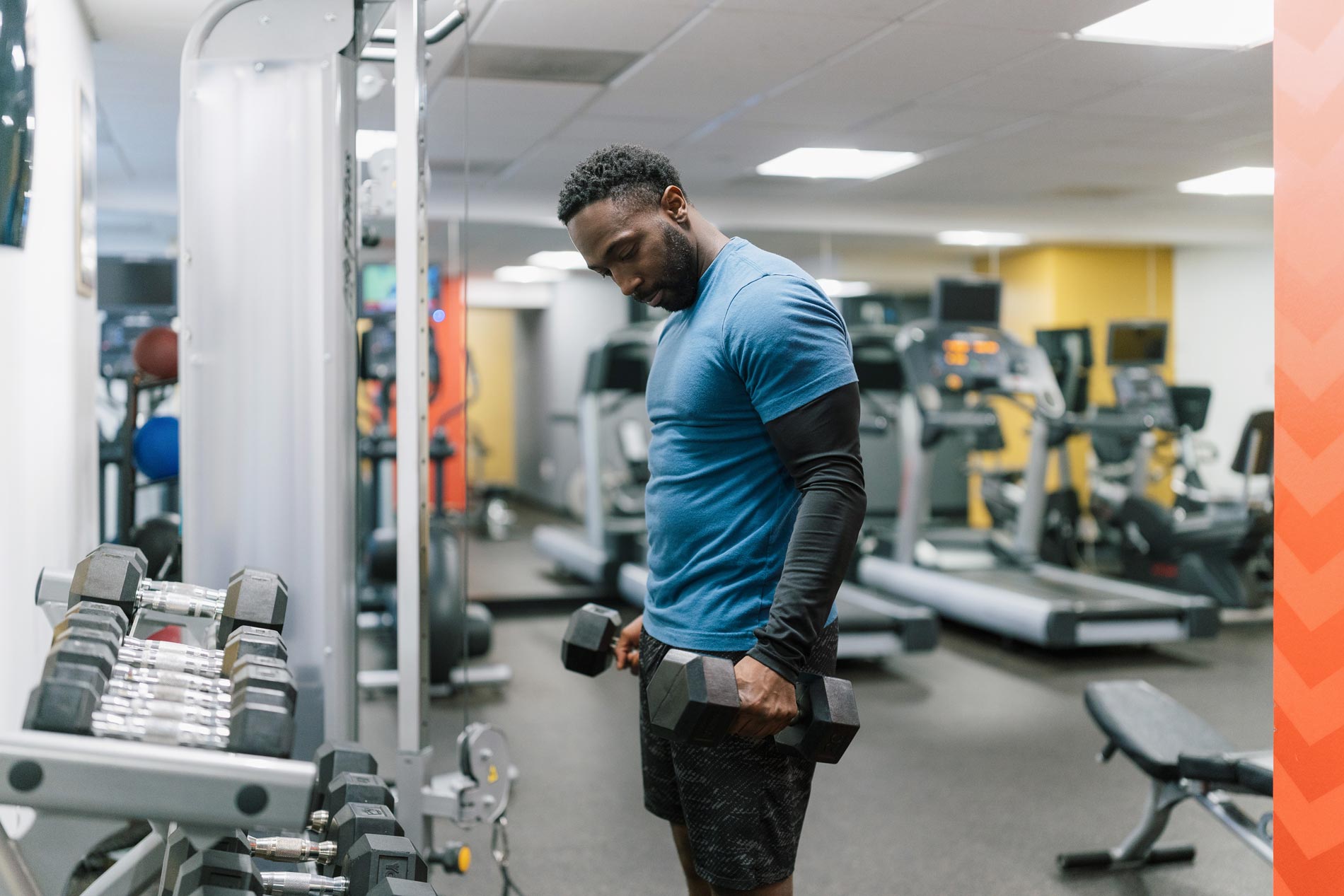 Andover House man holds free weights in gym