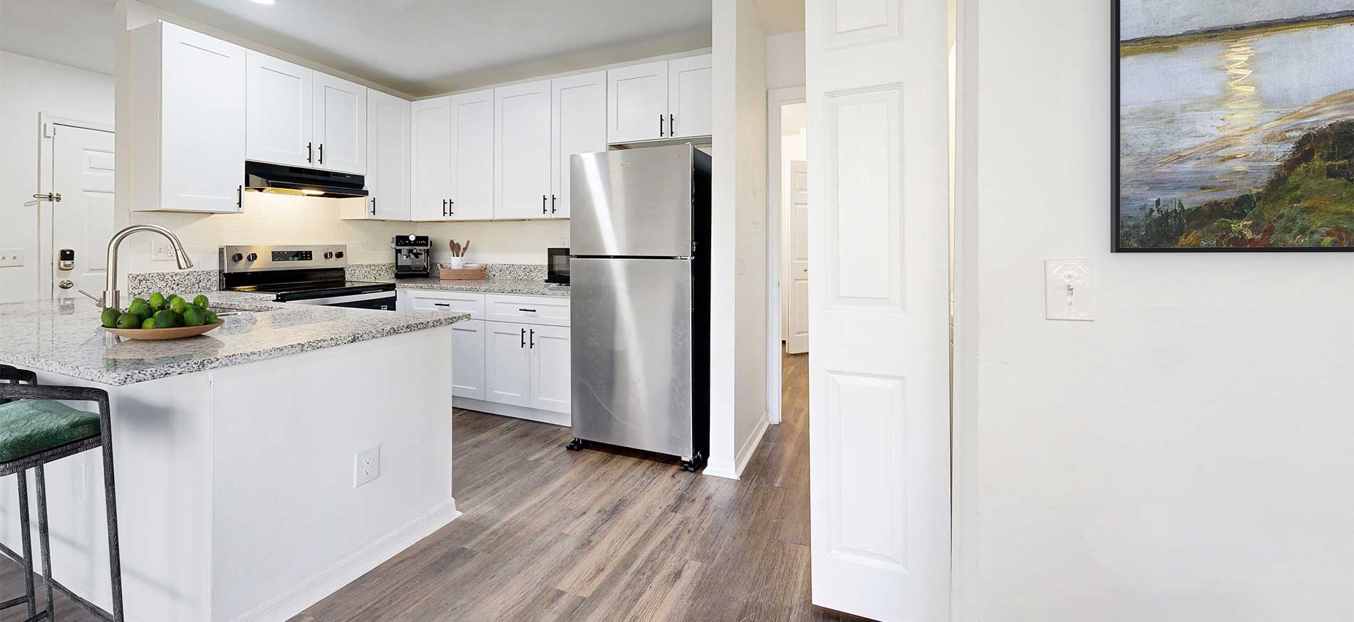 Staged kitchen with stainless steel appliances at Arbors at Lee Vista apartments in Orlando, Florida