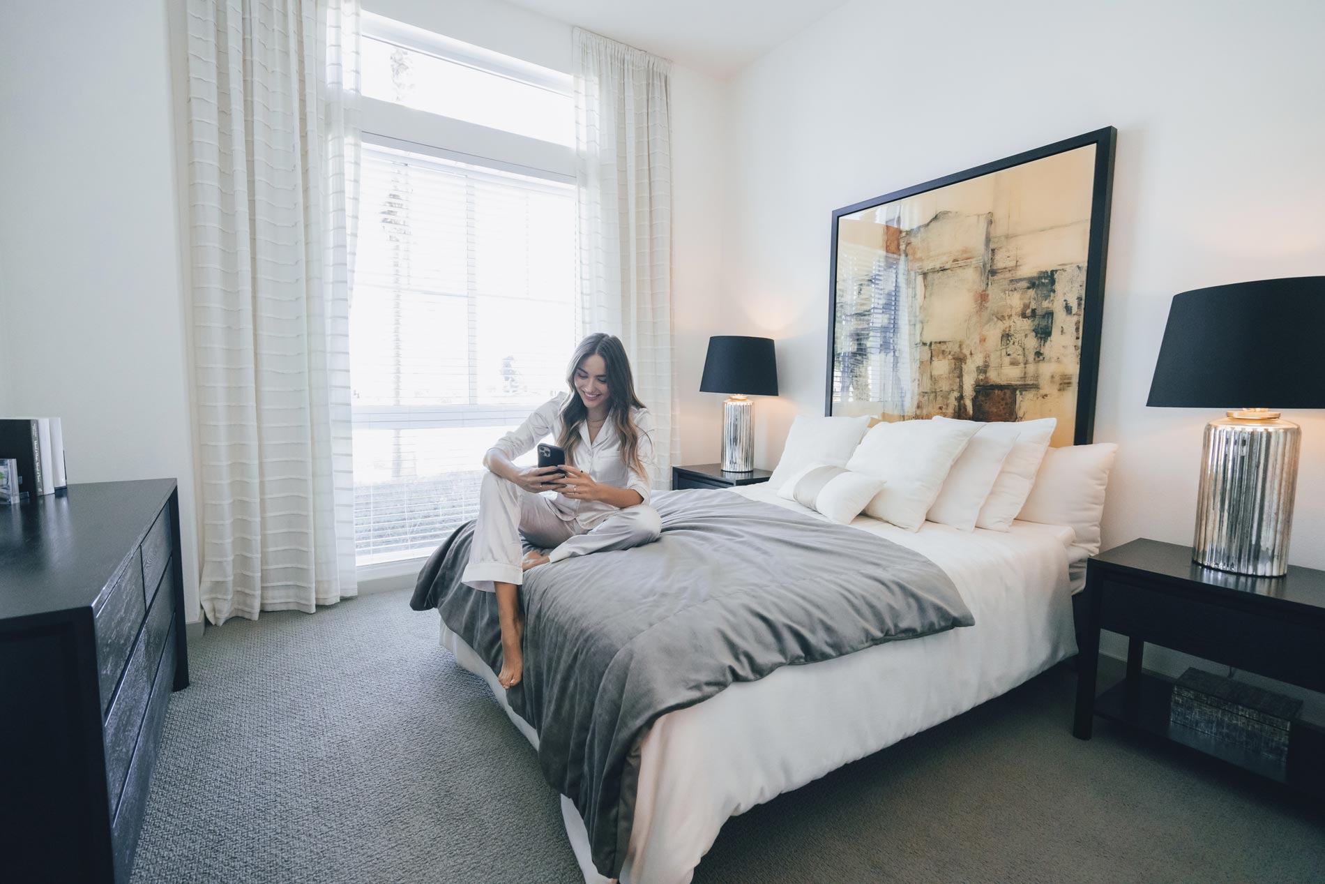 Beach and Ocean woman sits on bed with phone