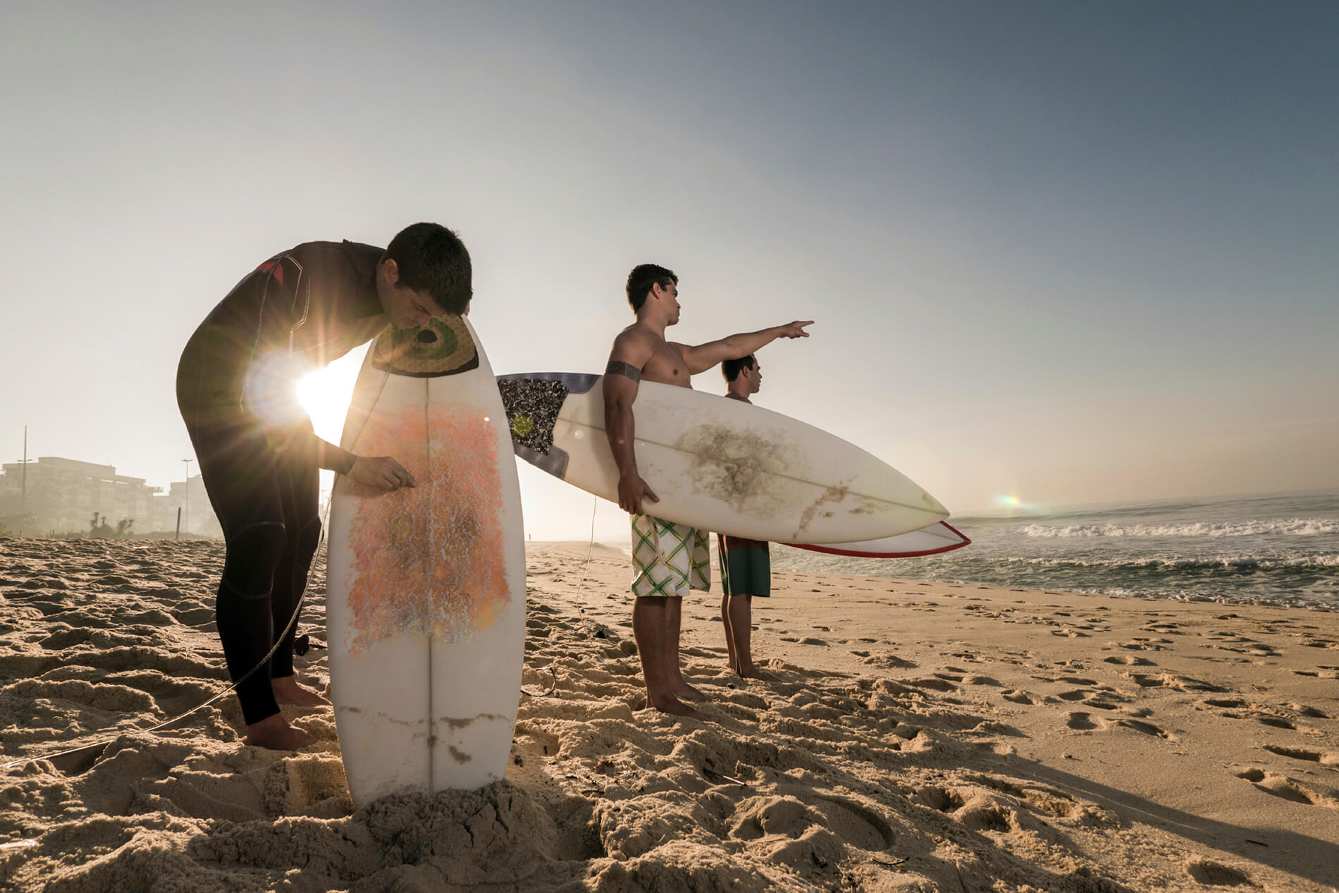 People standing with surfboards on the beach