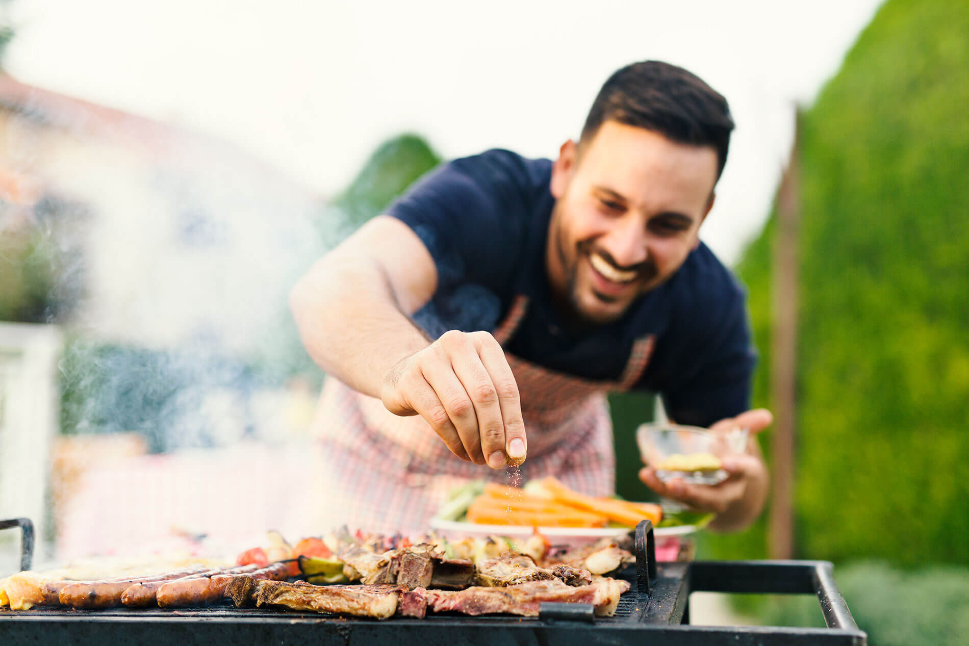 Man Seasons Food on a Grill