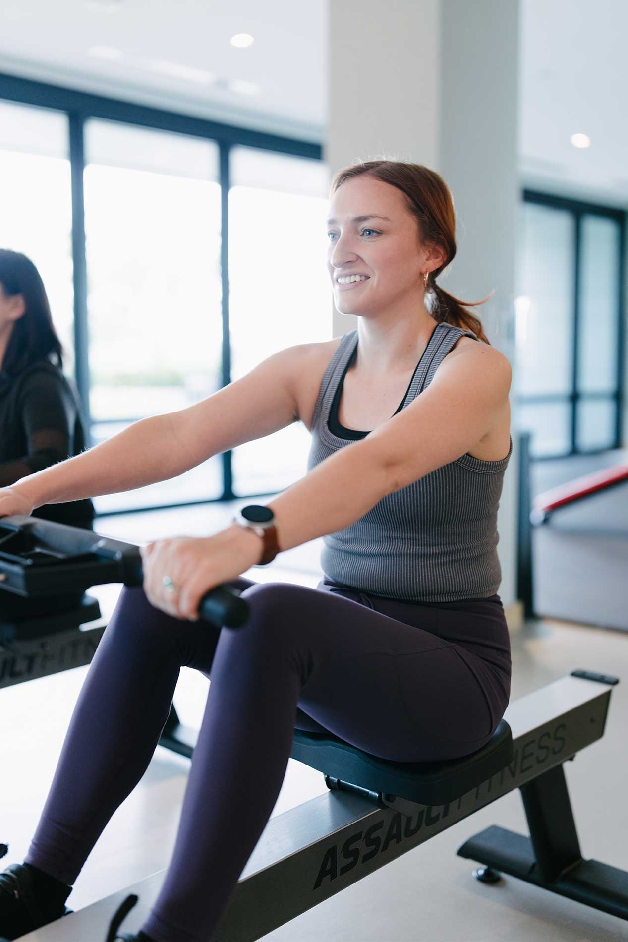 Woman using rowing machine in fitness center
