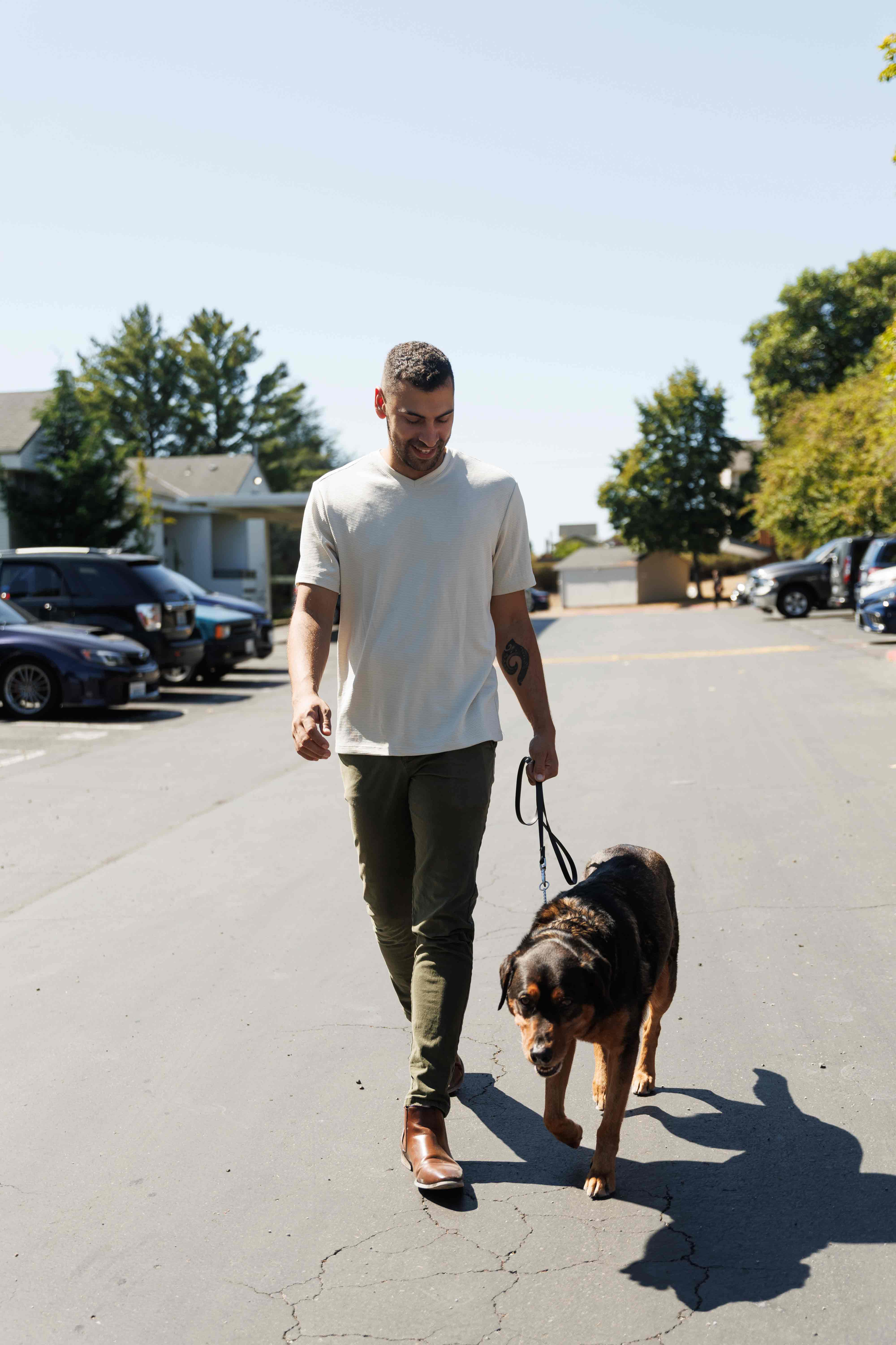 Man walks dog down street