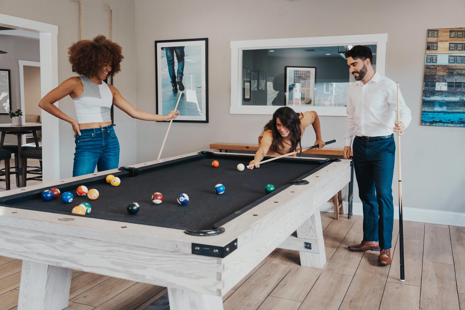 Cambridge Woods three people play pool in clubhouse