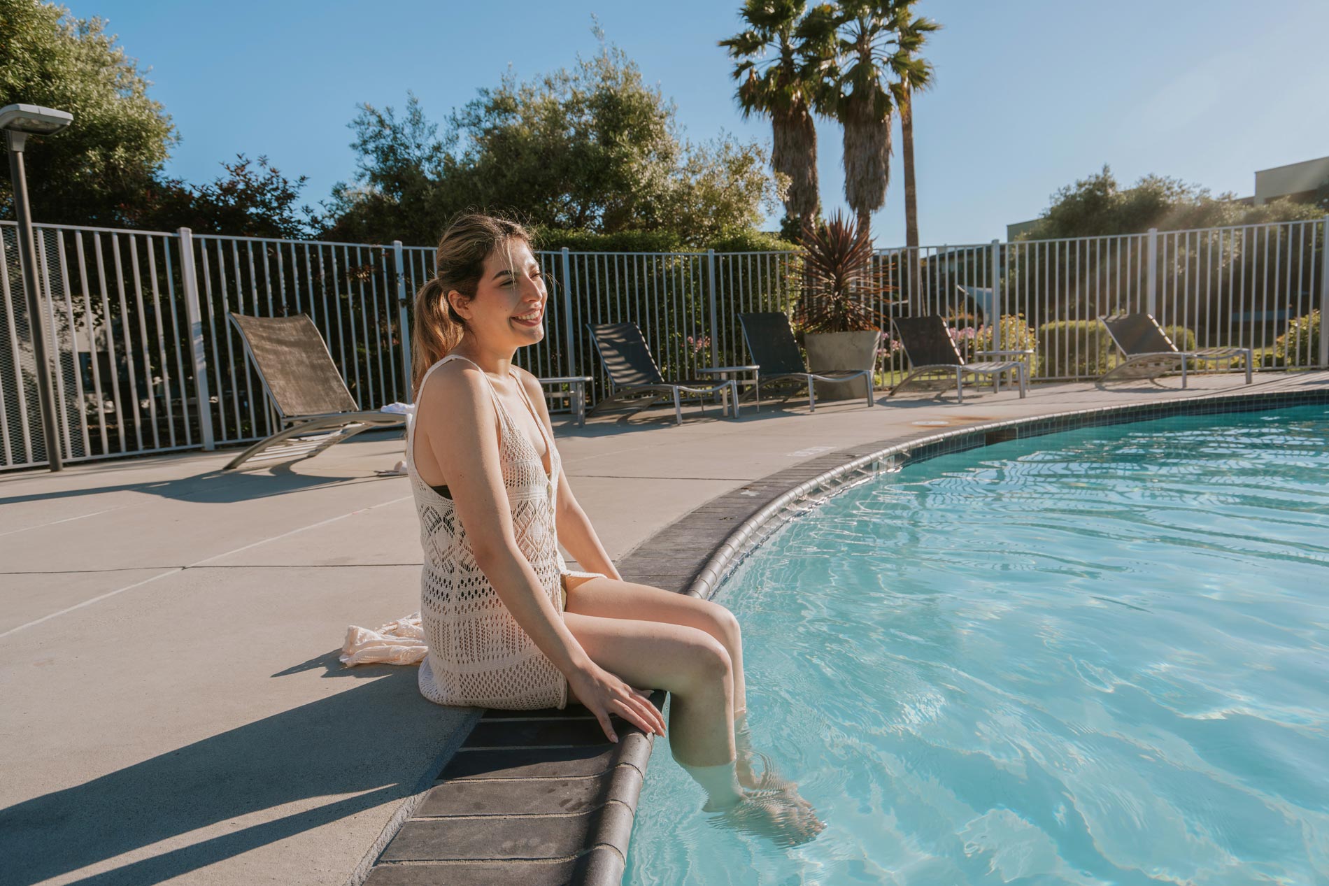 CitySouth woman sits on edge of pool