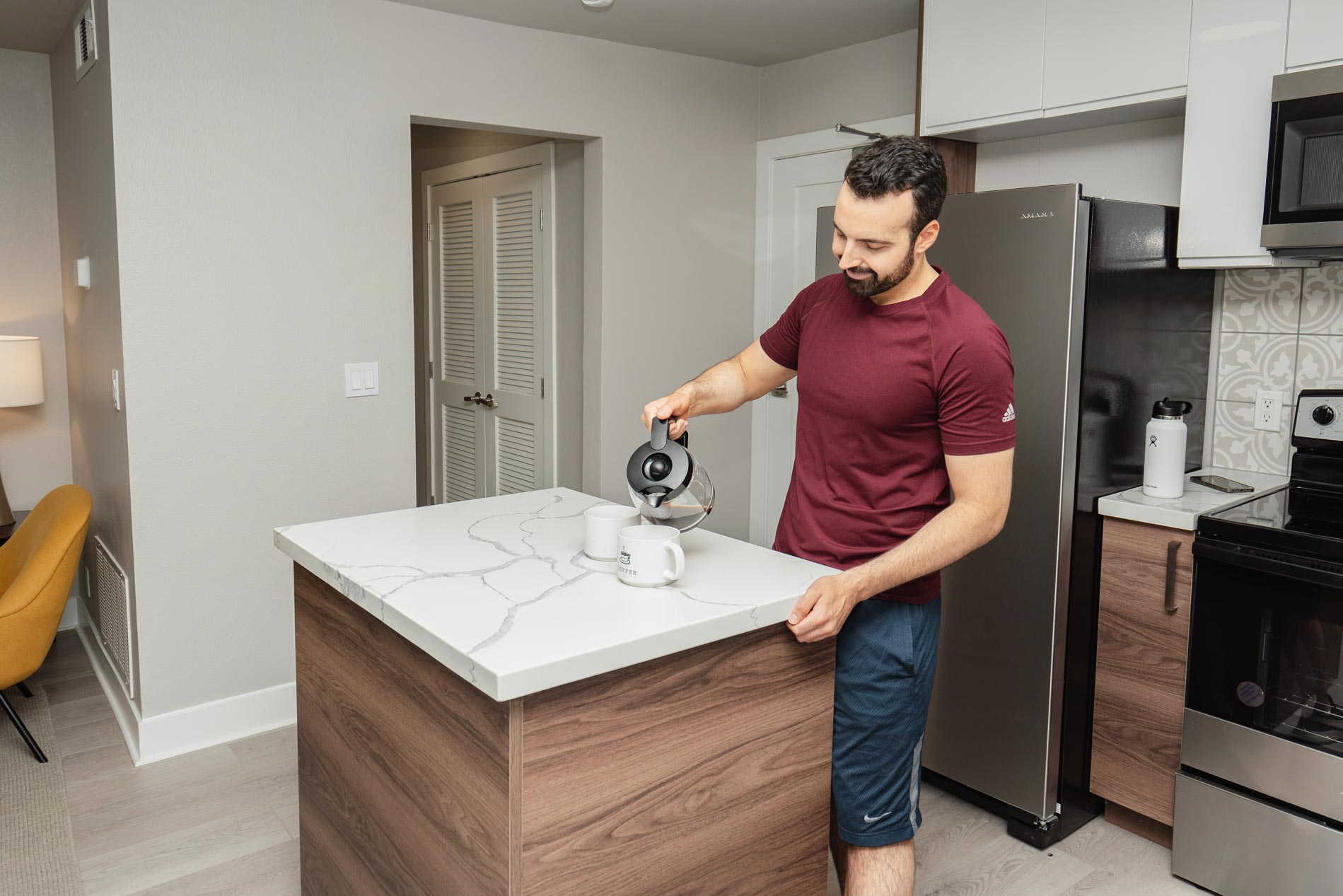 CitySouth man pours coffee in kitchen
