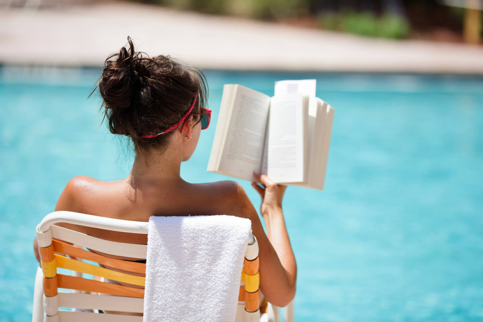 Woman reading by the pool