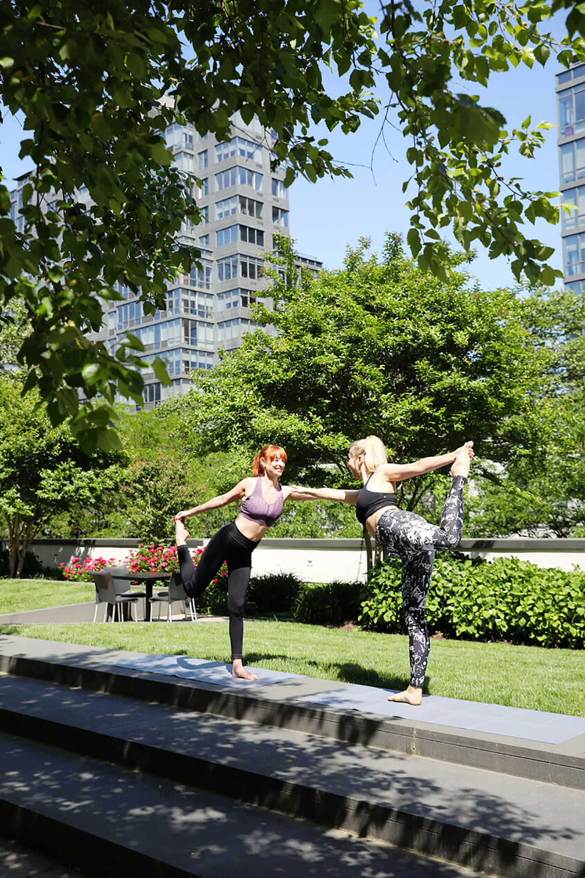 Two women doing yoga on patio