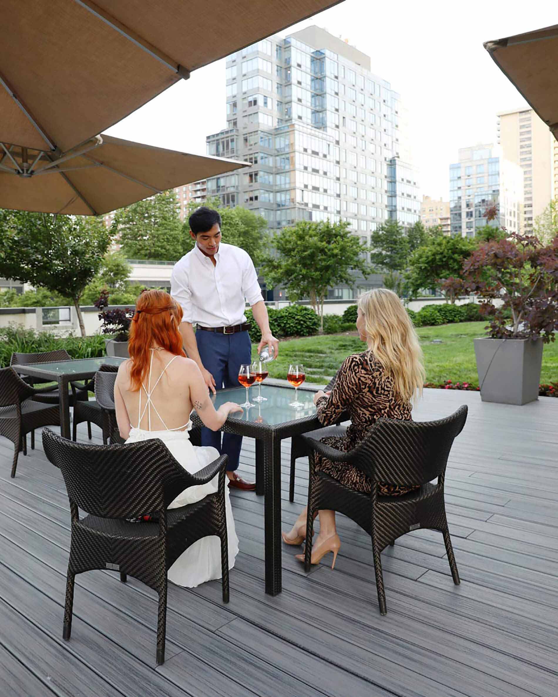 Friends sitting at table outside on Columbus Square patio