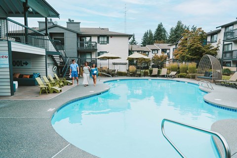 Crown Pointe three people walk by pool