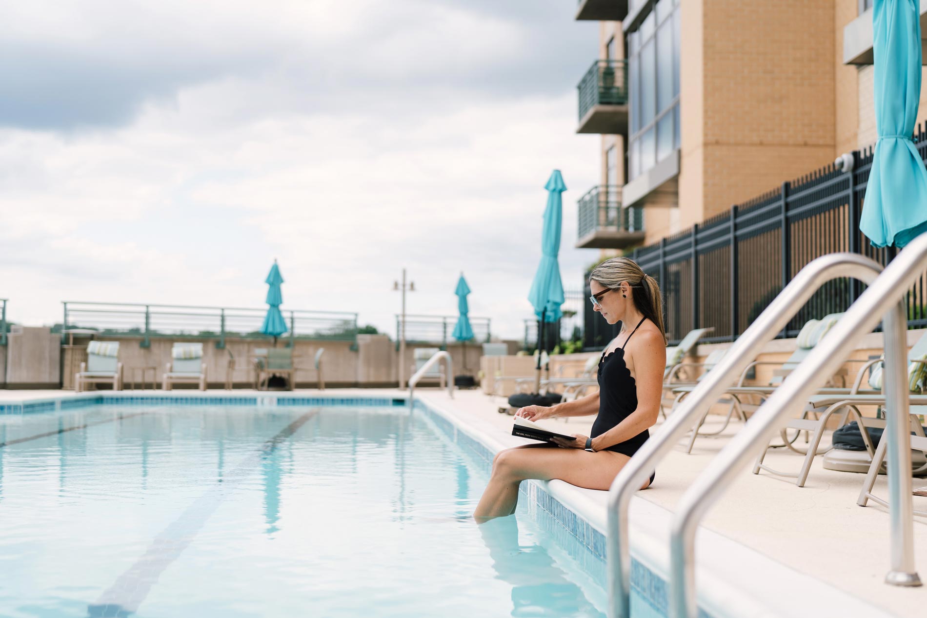 woman sitting on edge of pool