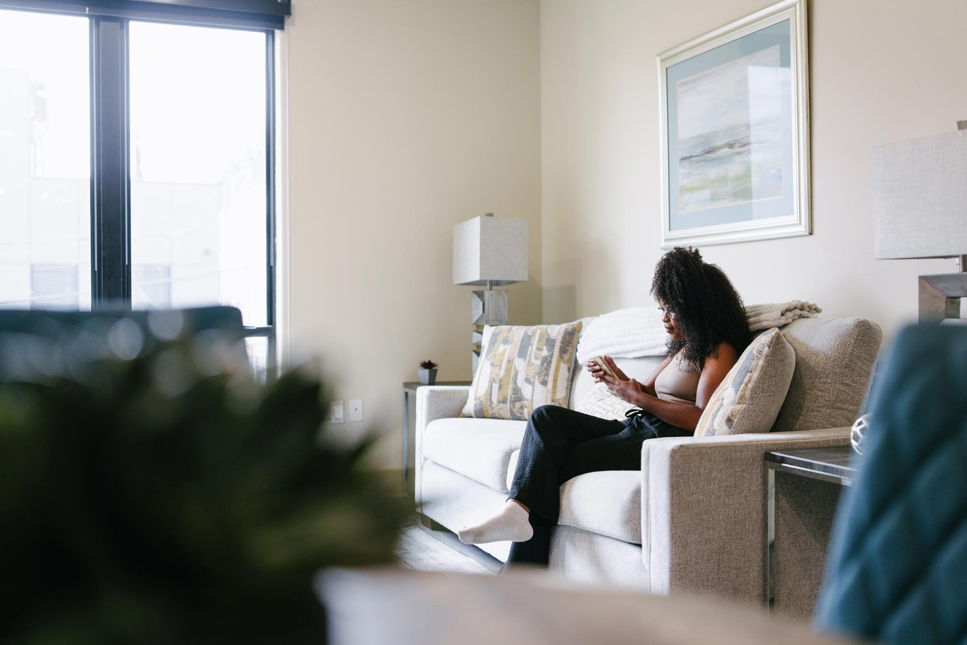 Domain Brewers Hill woman sits on living room couch