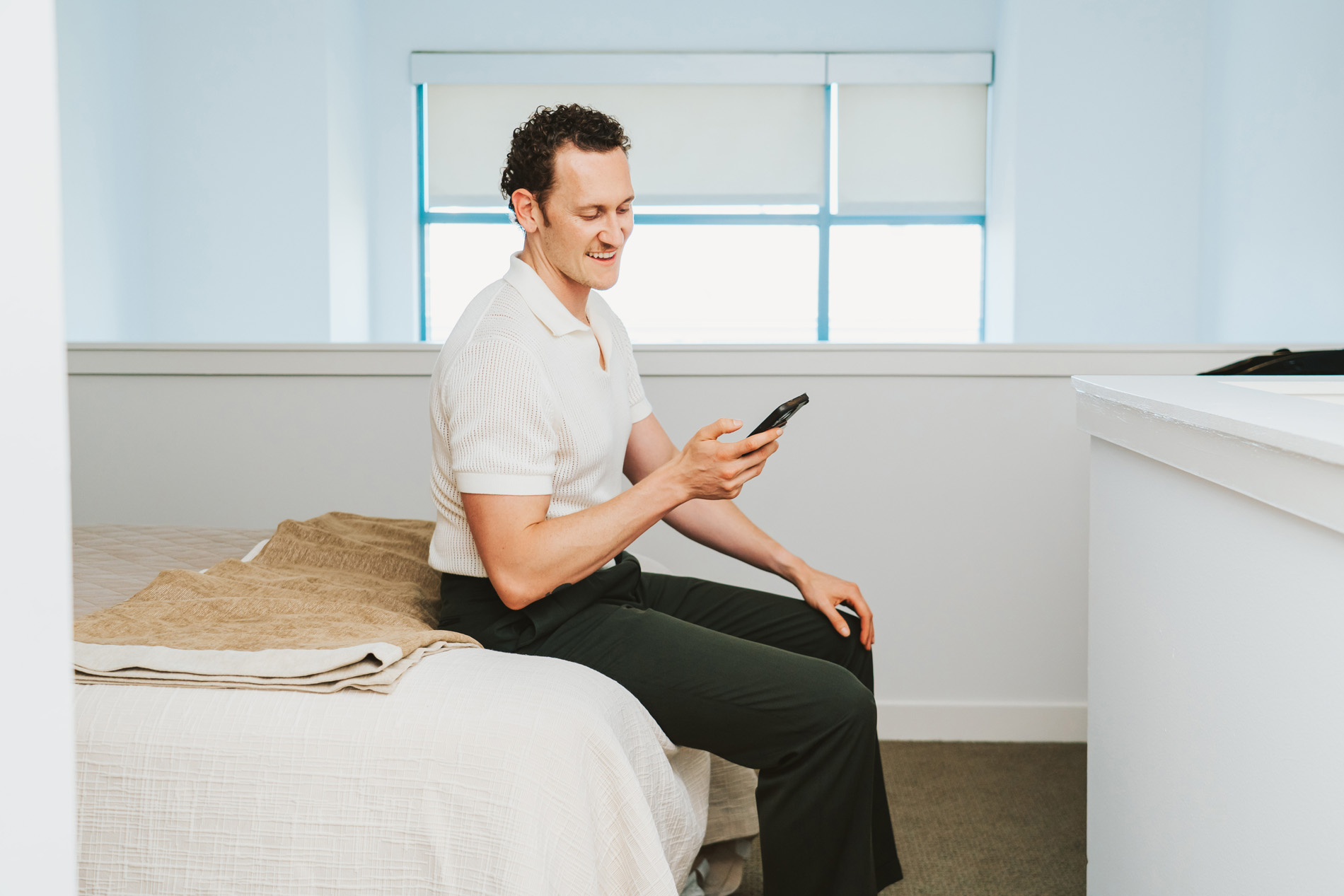 Edgewater man uses phone while sitting on bed