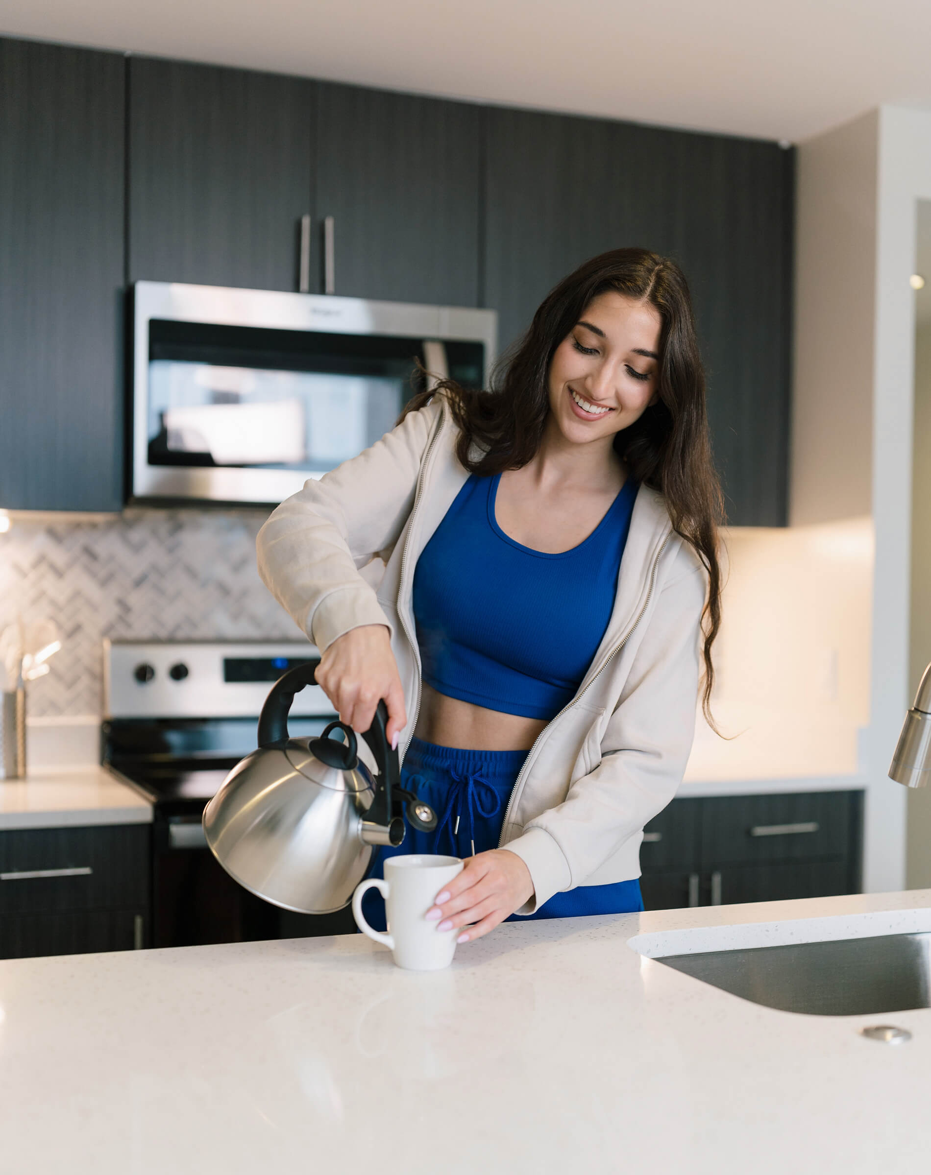 Eleven 55 A woman pours coffee in the kitchen