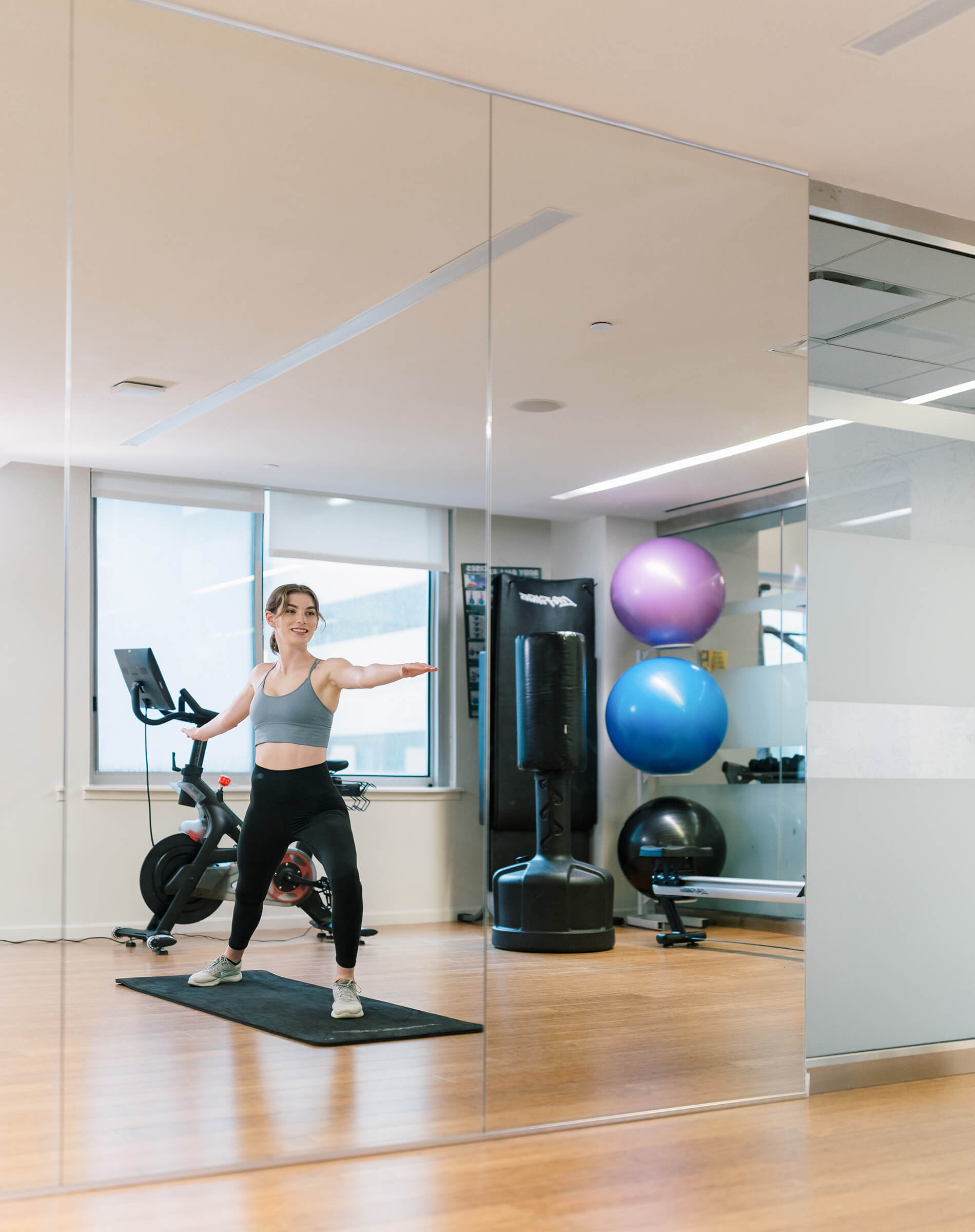 Eleven 55 woman does yoga in fitness room