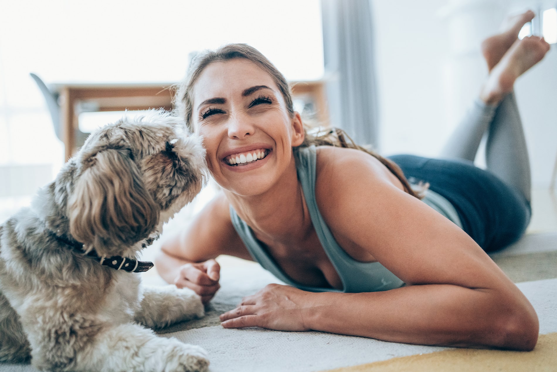 Woman and dog playing on floor together