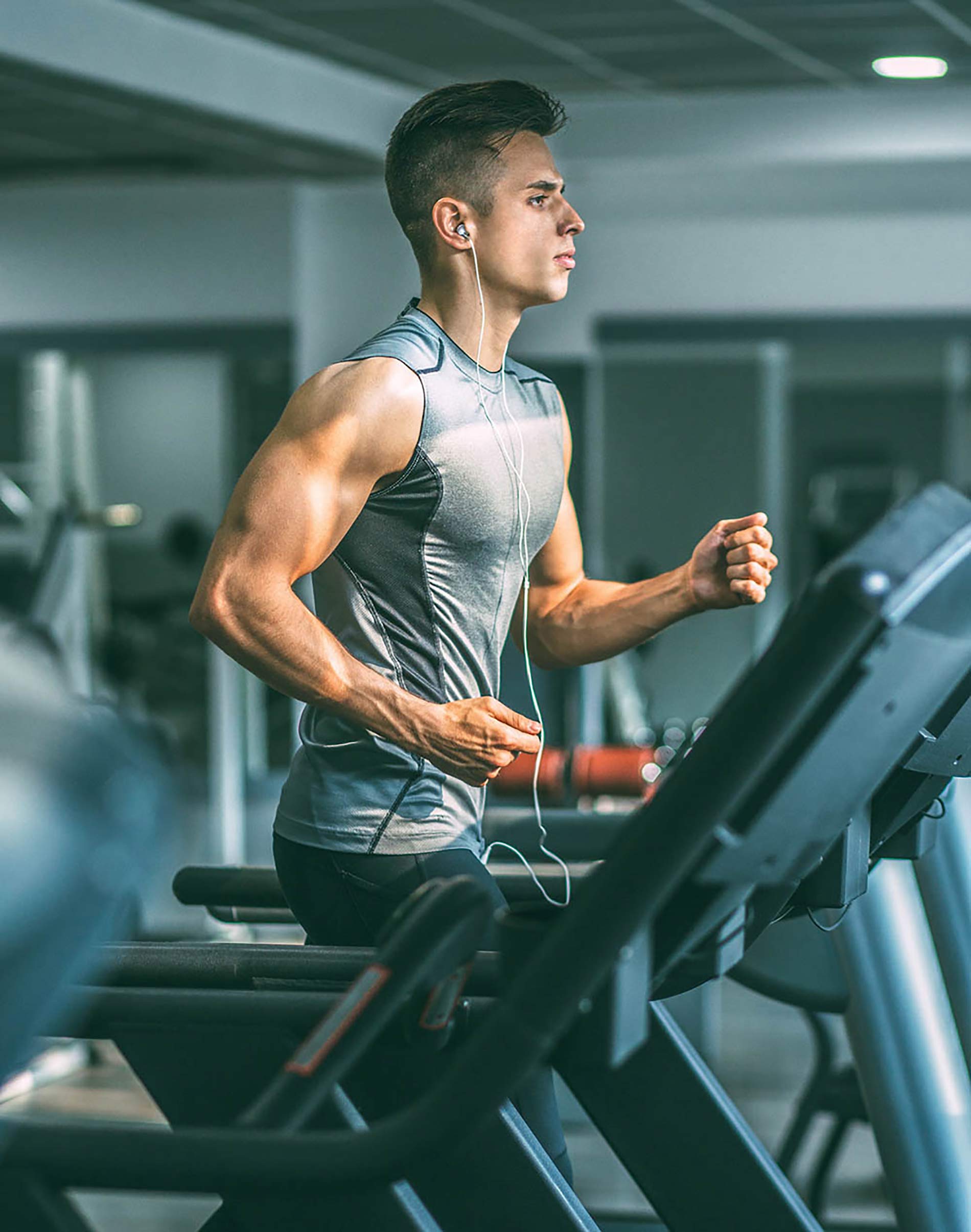 Muscular man running on treadmill