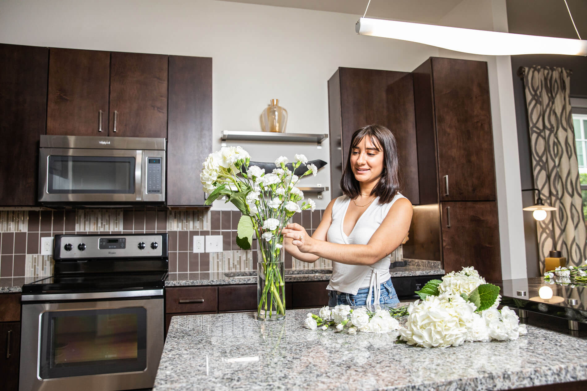 Woman cutting flowers in kitchen