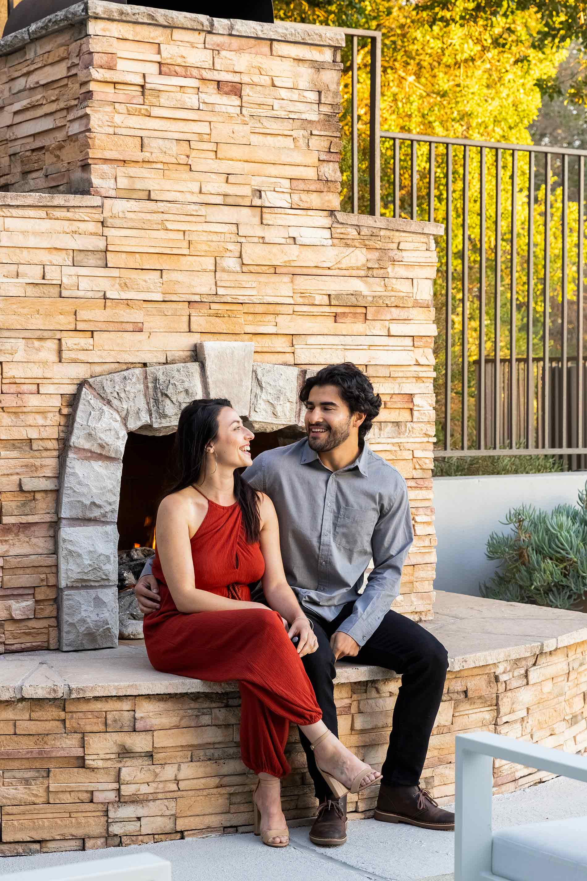 Highlands Of Marin couple sits on fireplace