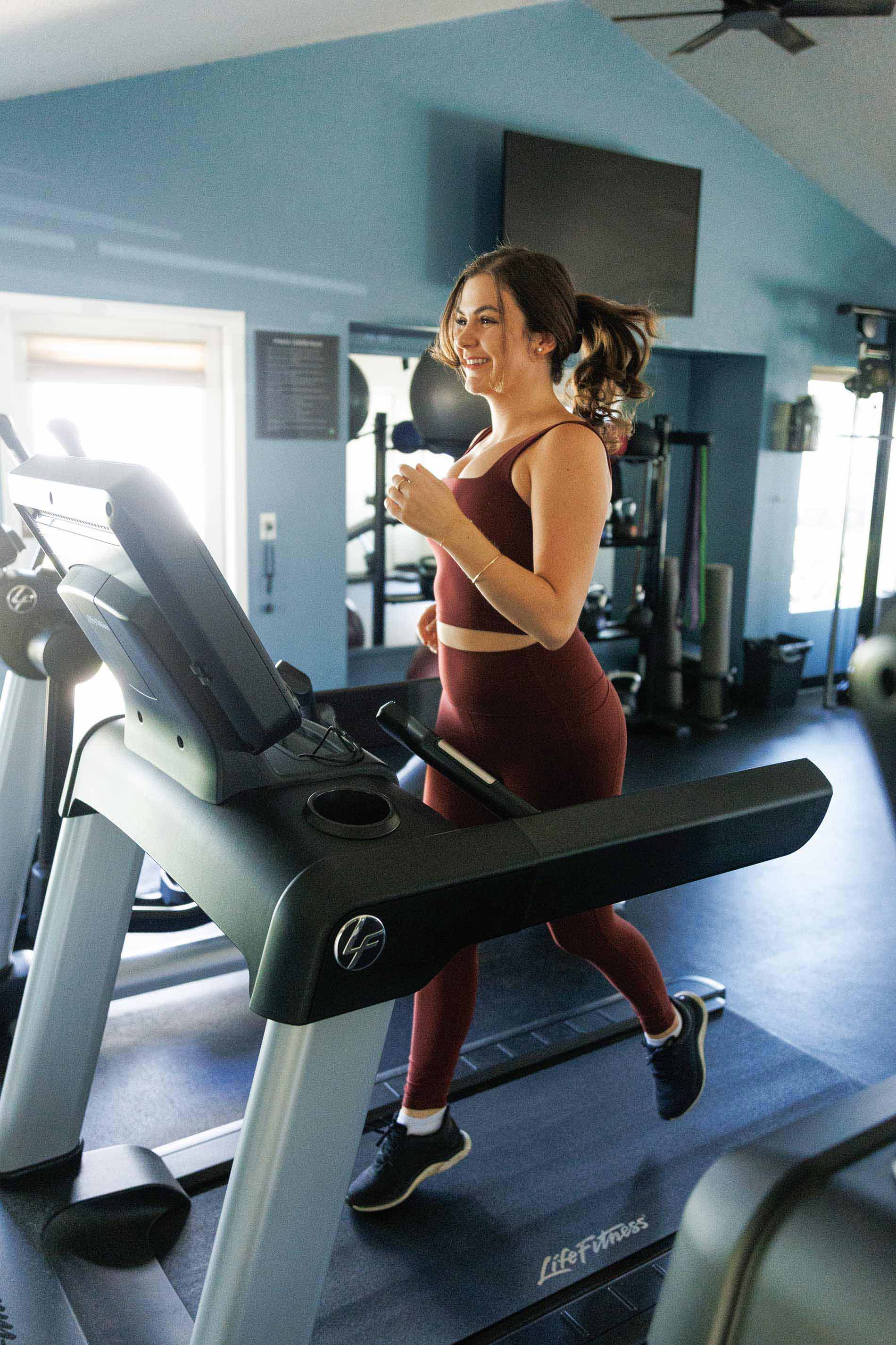 Hilltop woman on treadmill in gym
