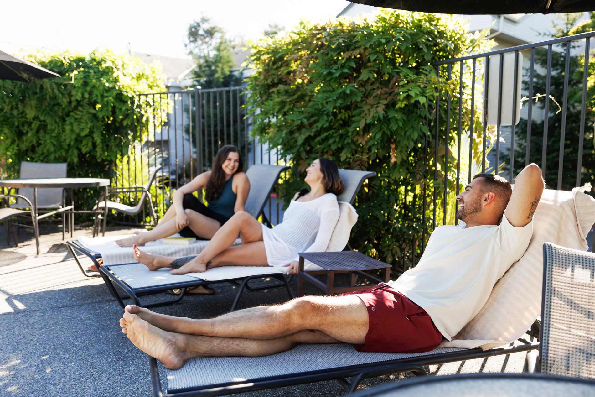 Hilltop three people sit by pool
