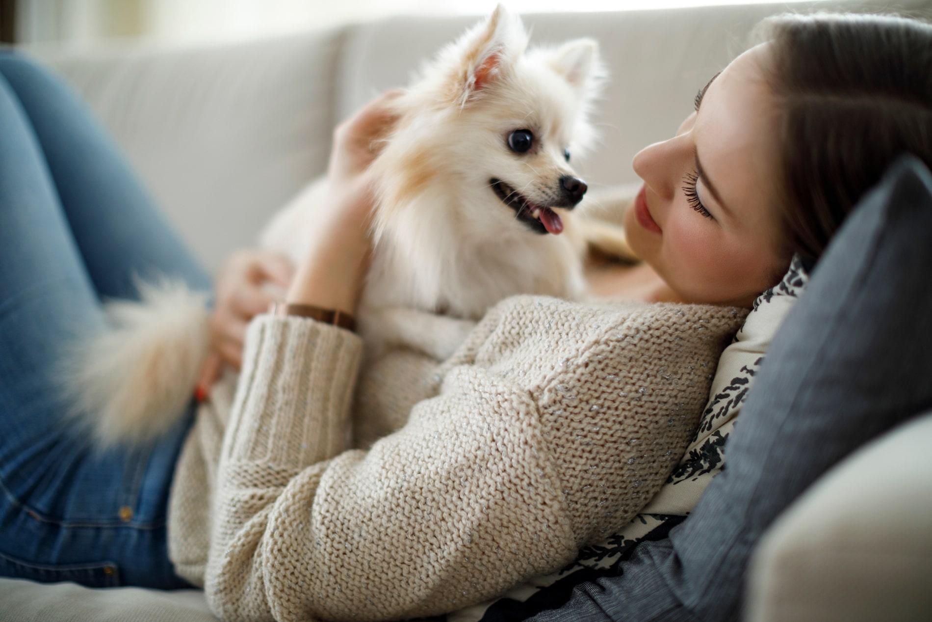 Woman on couch with small white dog