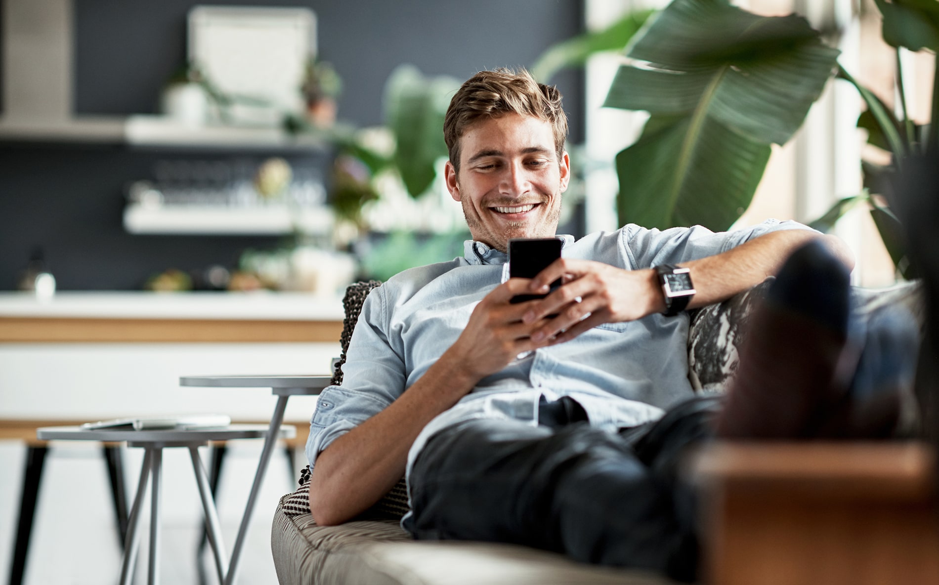 Man on couch using smart phone