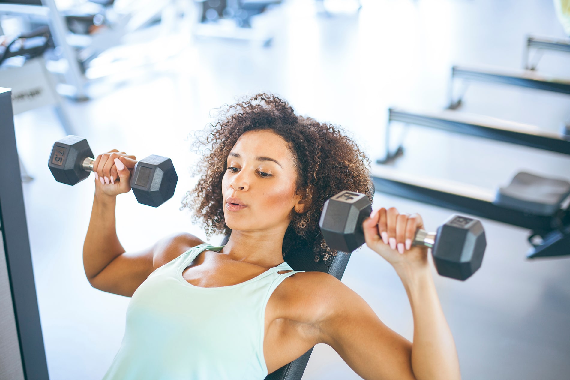 Woman using weights in fitness room