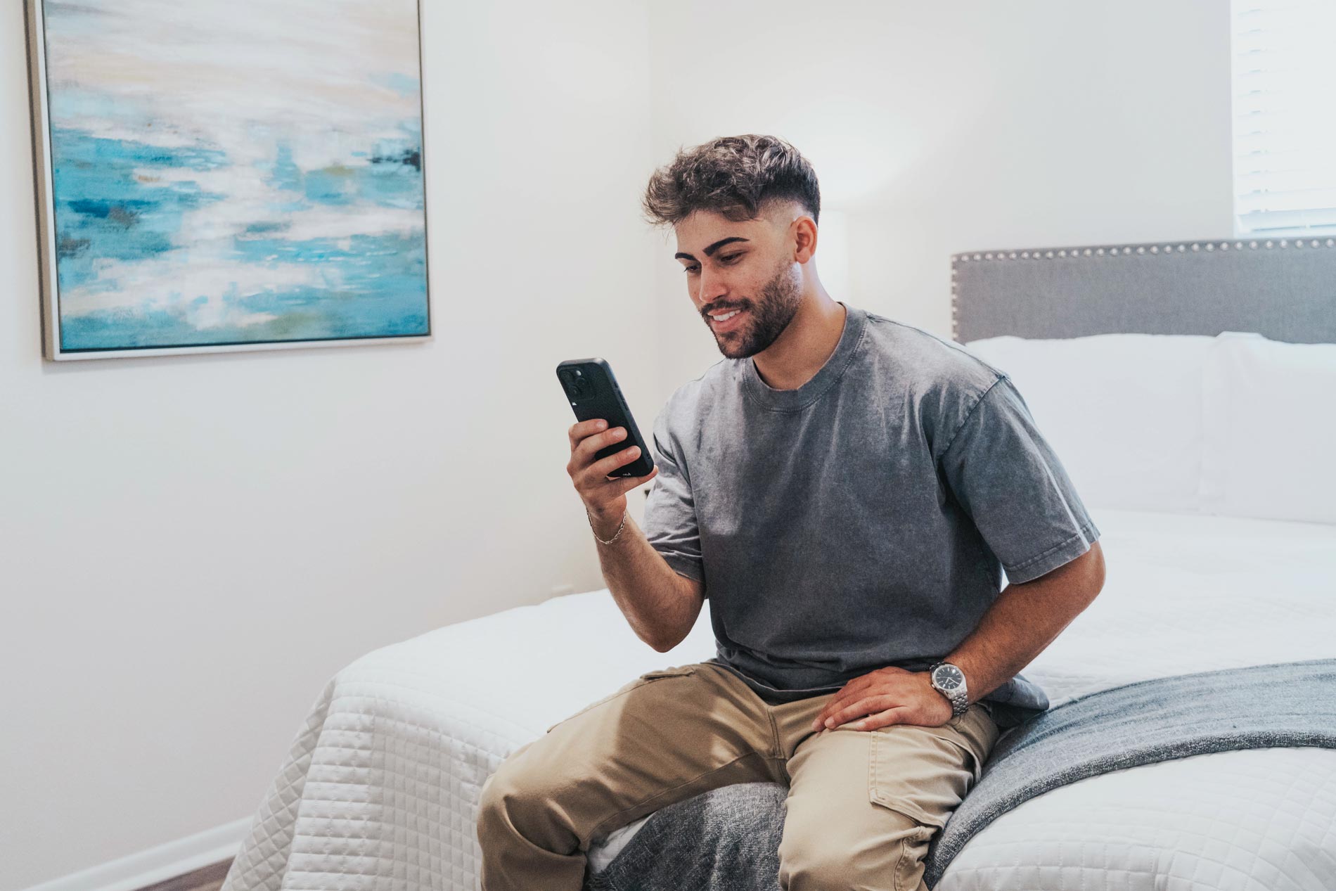 Inlet Bay man sits on phone in bedroom