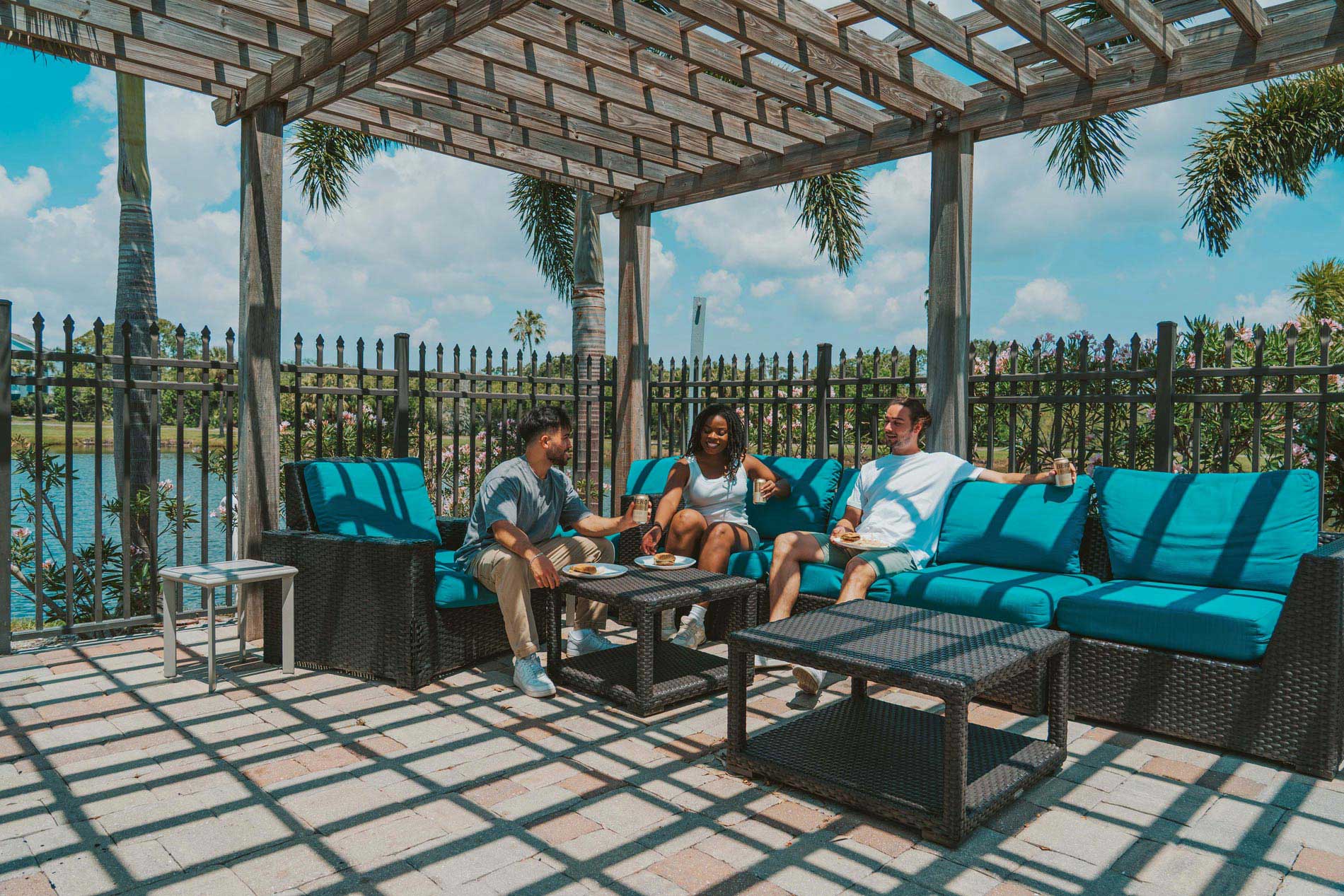 Inlet Bay three people sit in outdoor lounge area