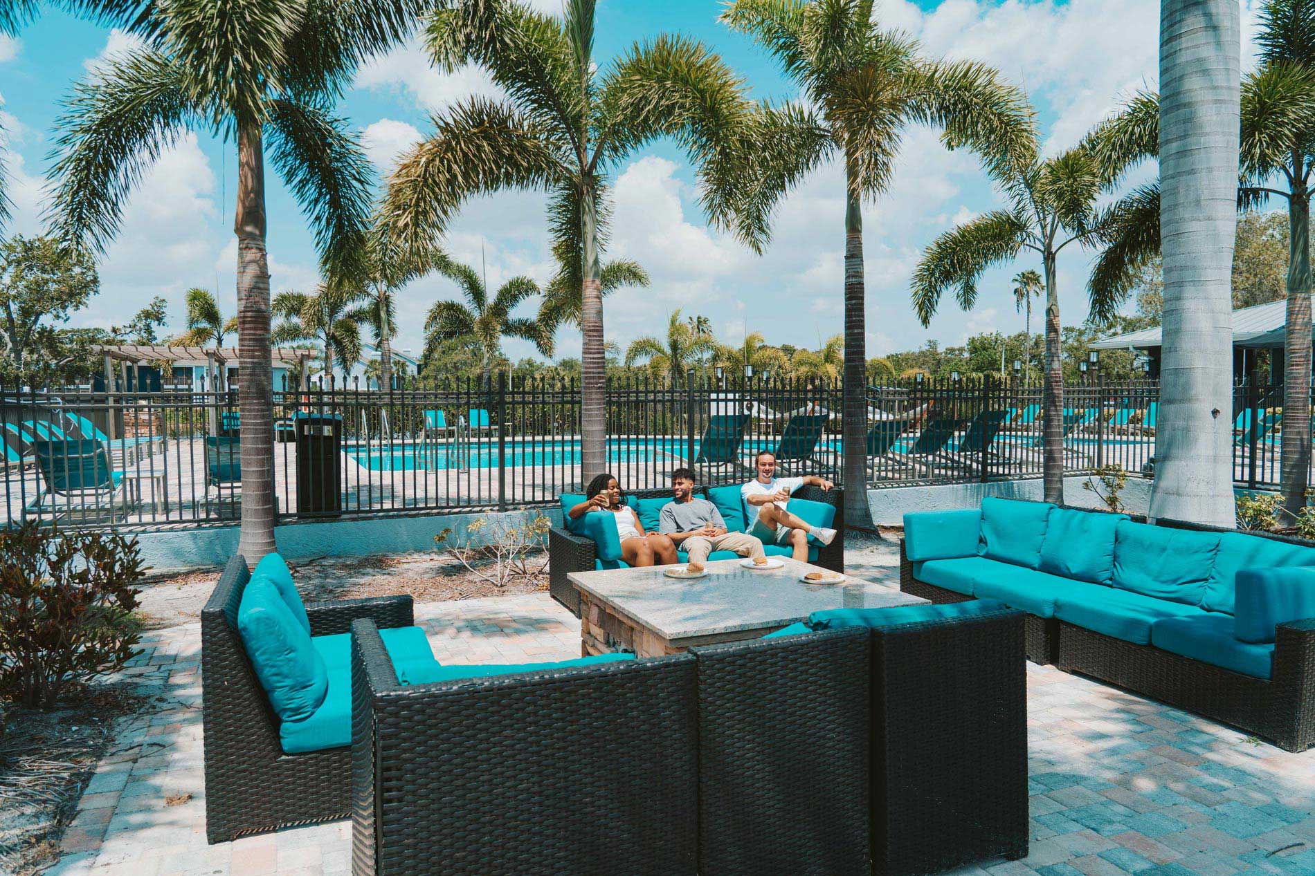 Inlet Bay three people sit in outdoor lounge area