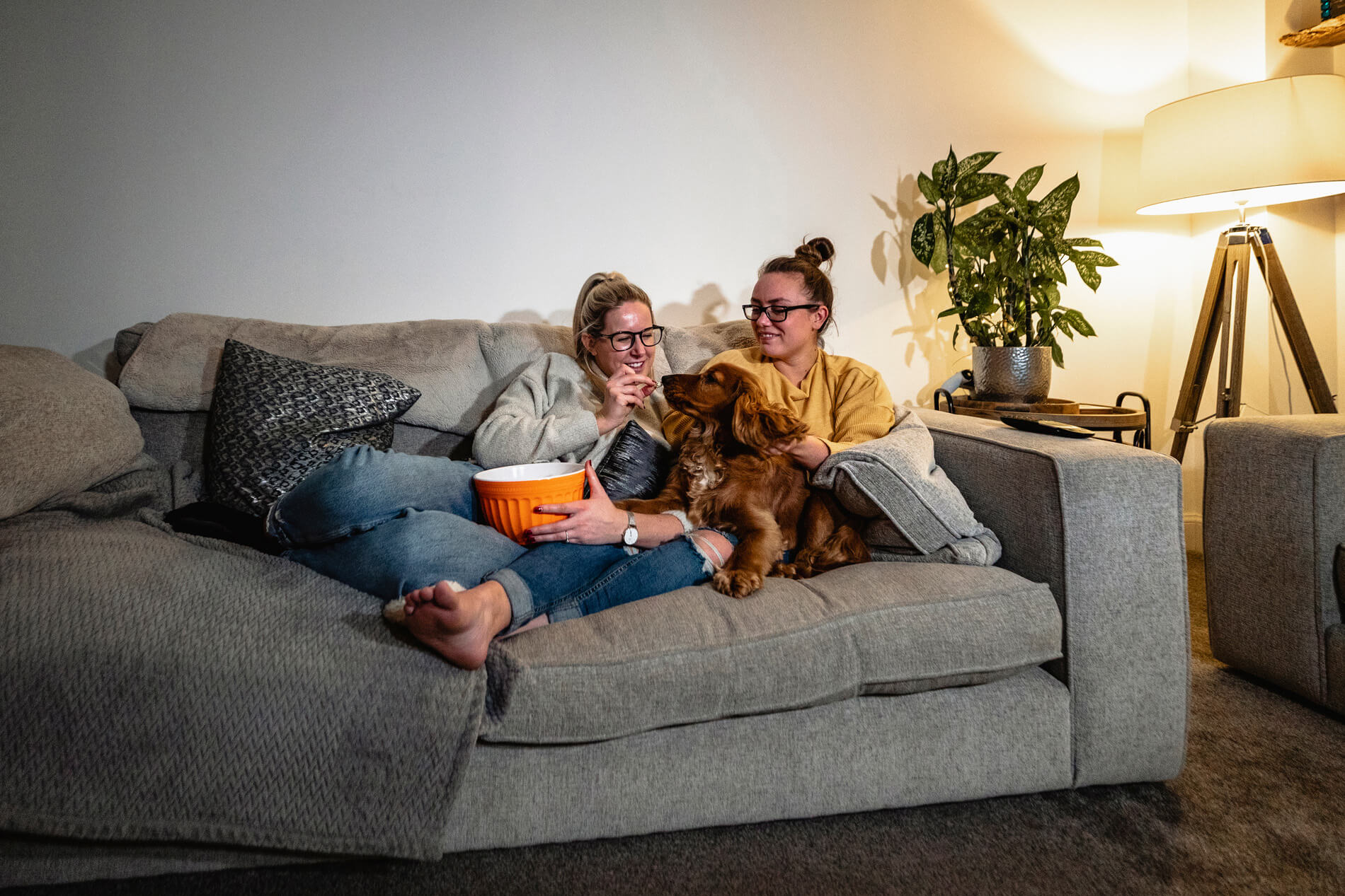 People sitting on the couch with a dog