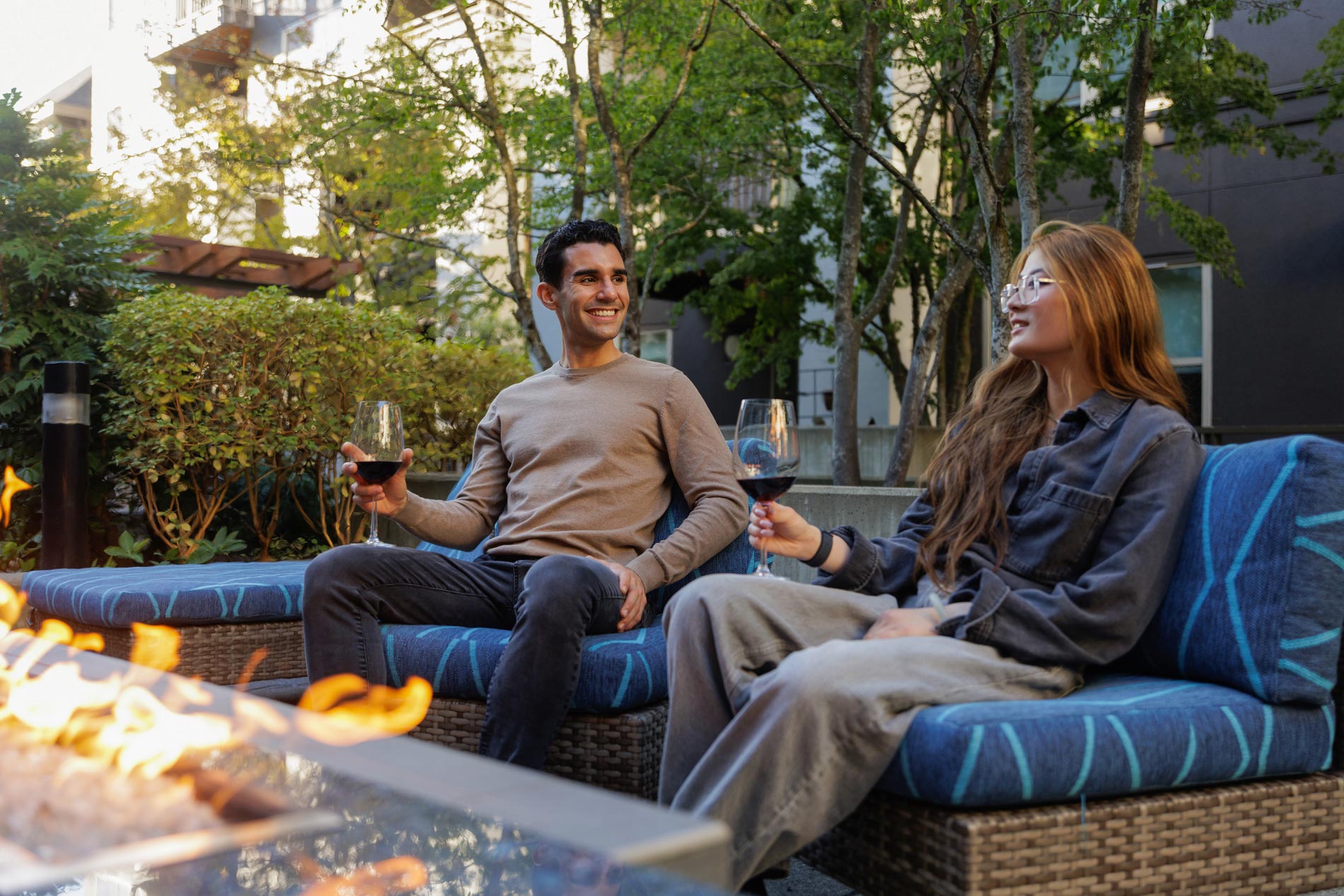 Island Square two people sit by fire pit
