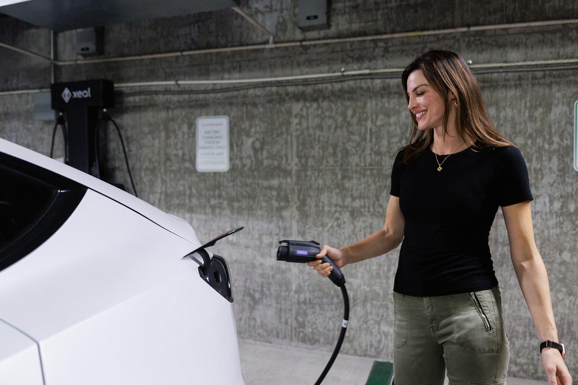 Island Square woman plugs in car to EV