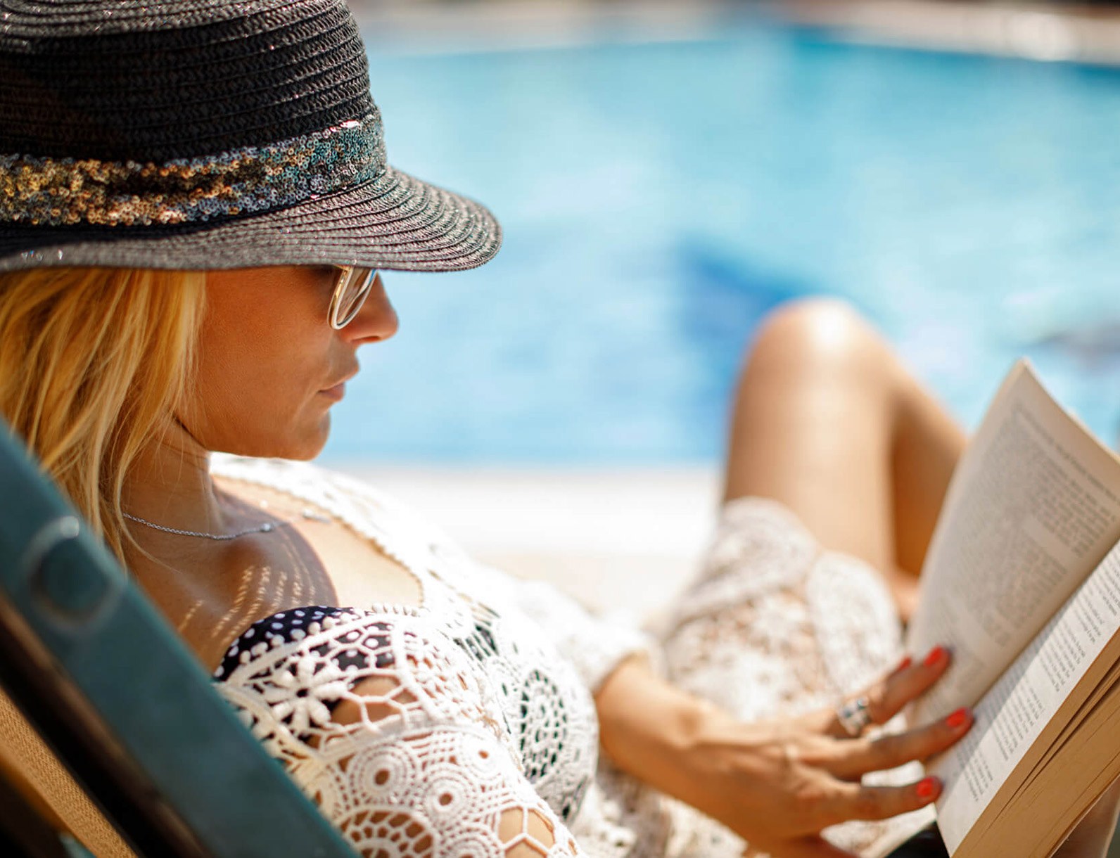 Woman reading by the pool