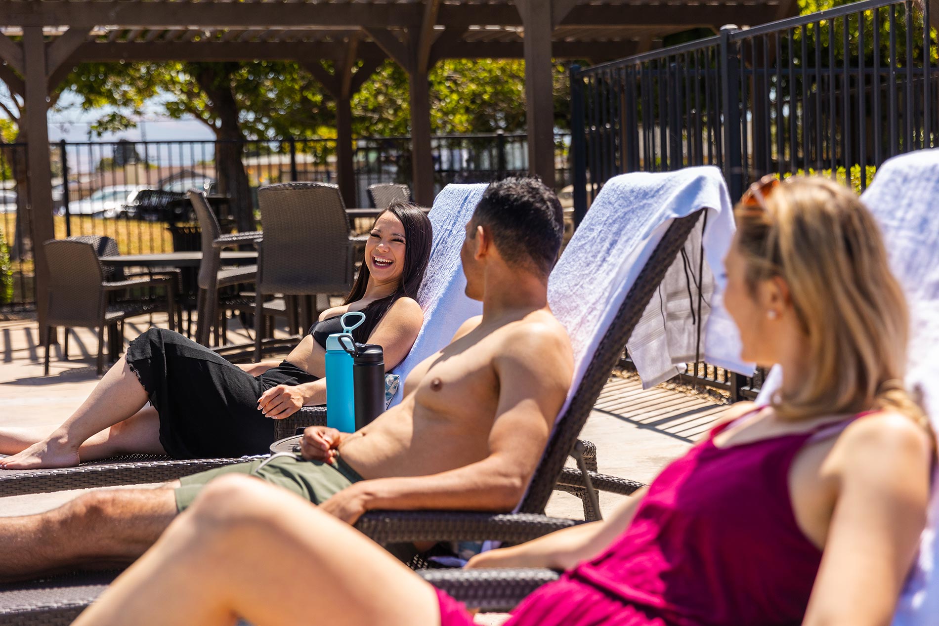 Laurel Tree three people lay by pool