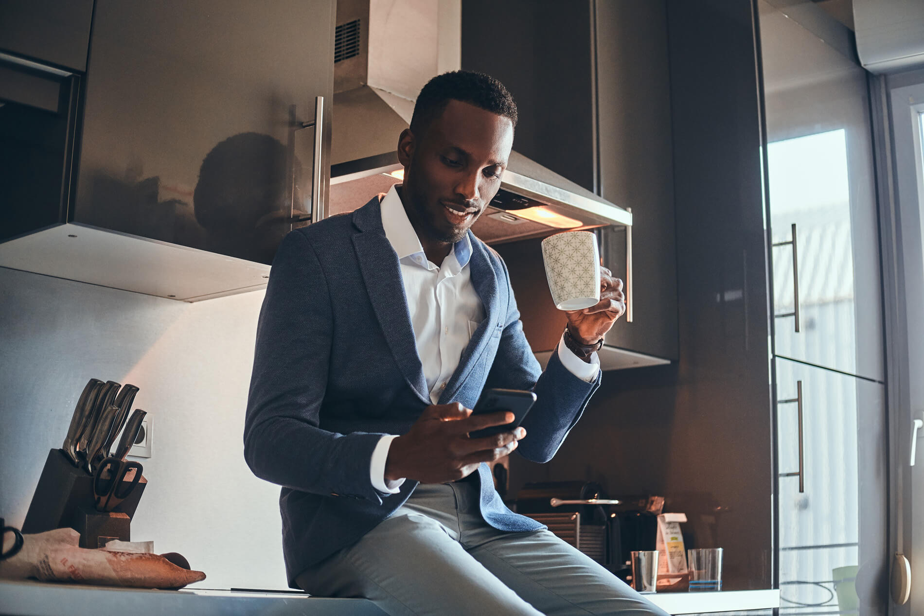 Man drinking coffee looking at his phone