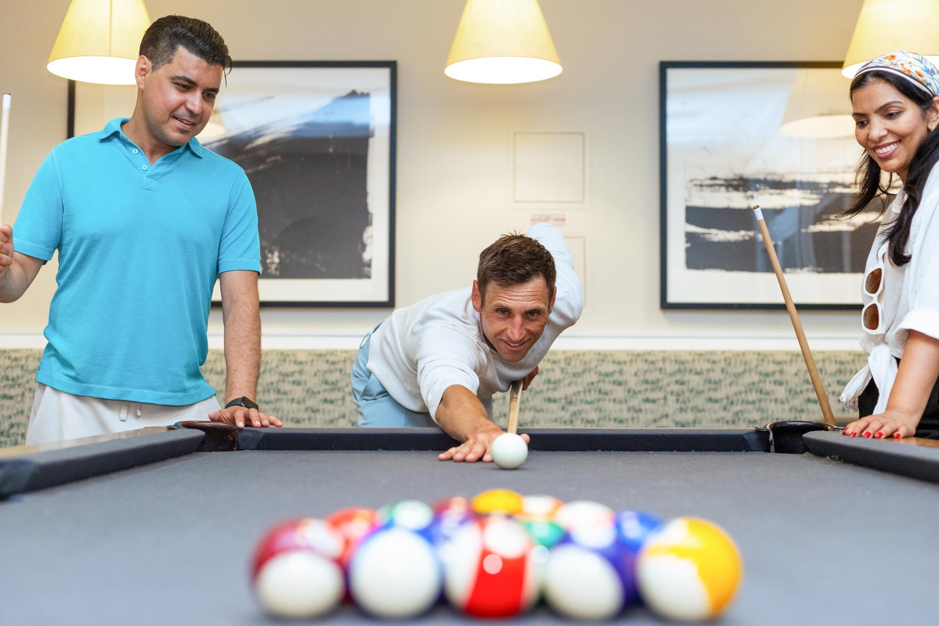 One Upland three people play a game of pool
