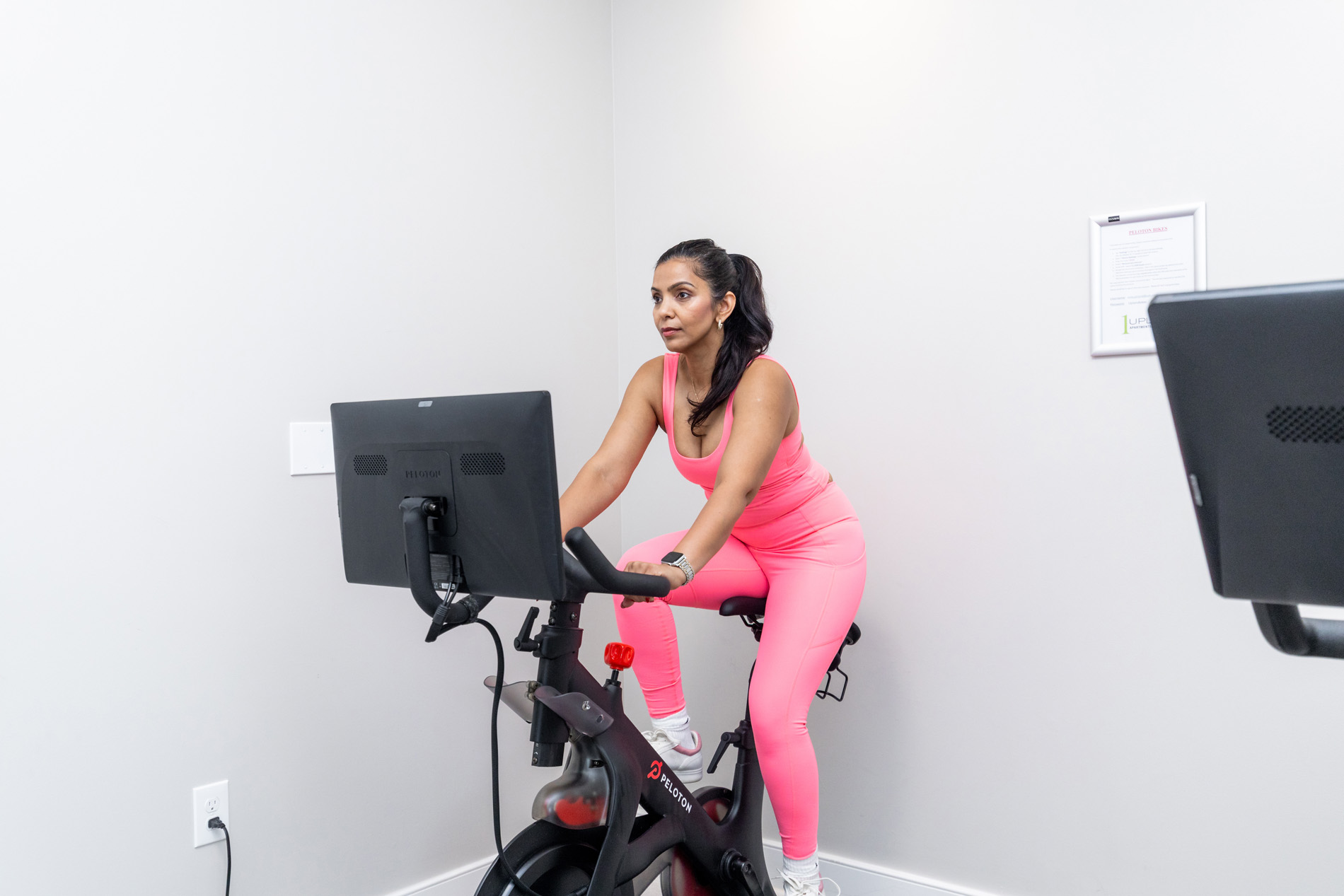 One Upland woman rides stationary bike in gym