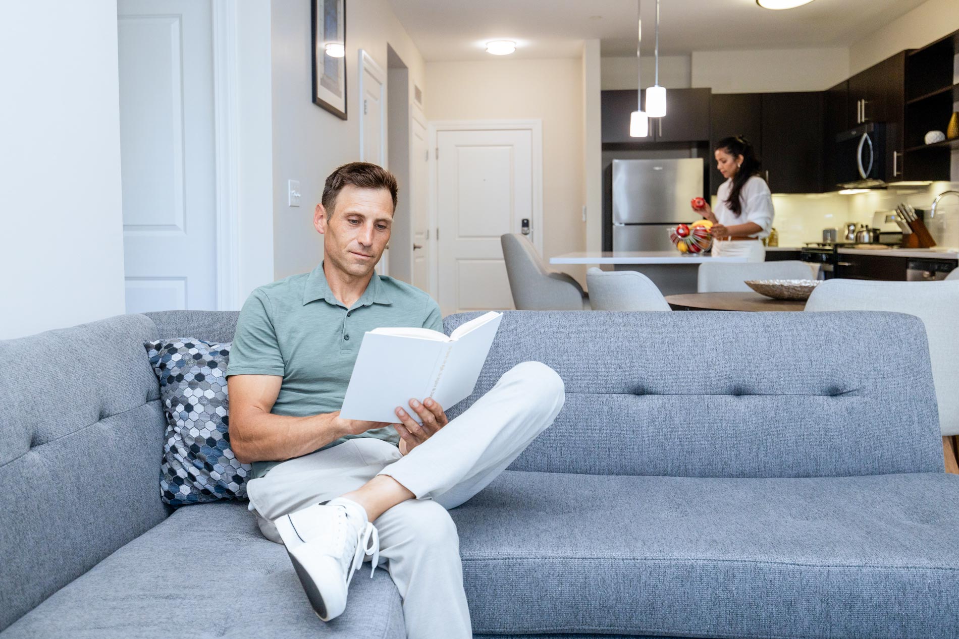 One Upland man reads on couch