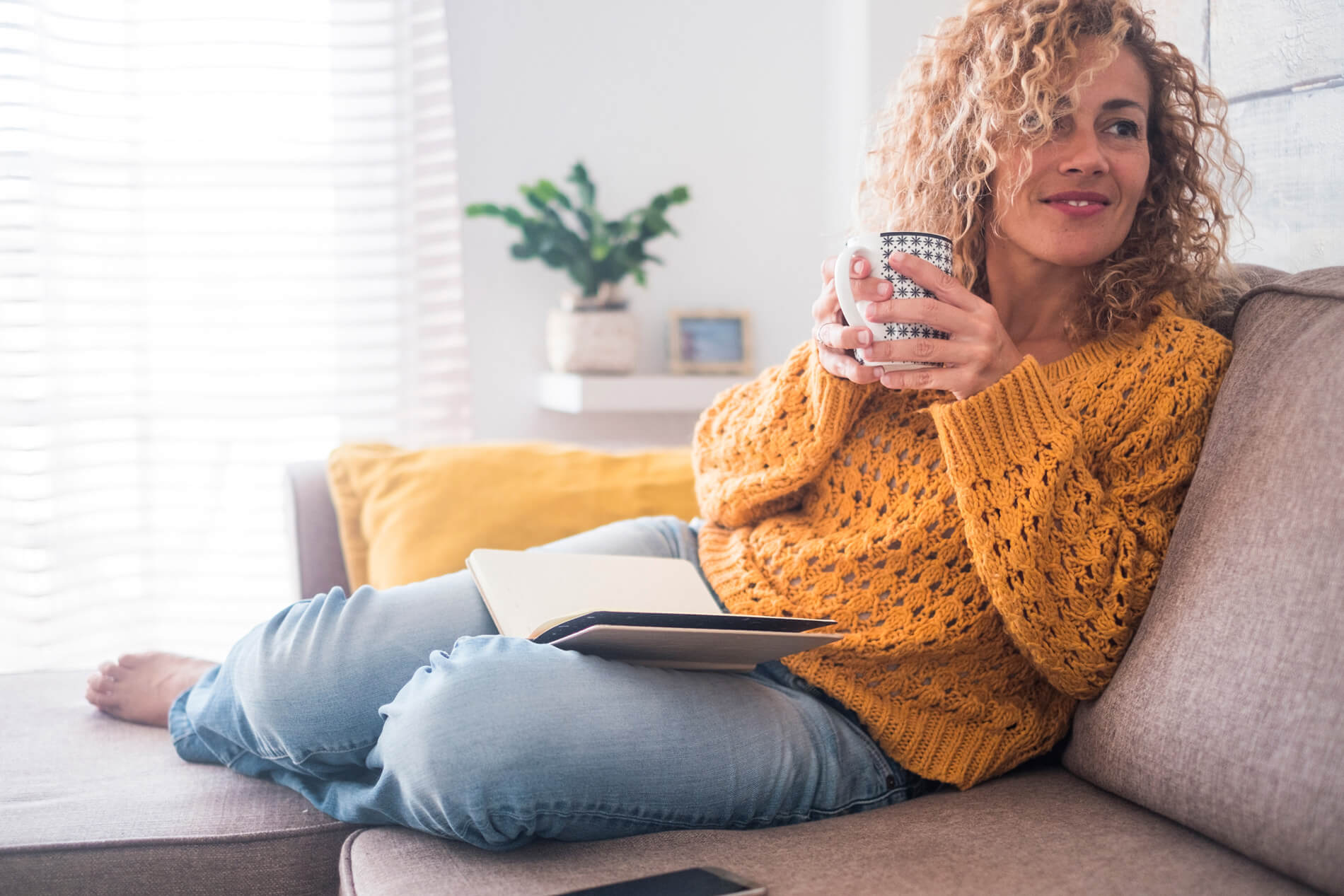 Woman drinking coffee on the couch